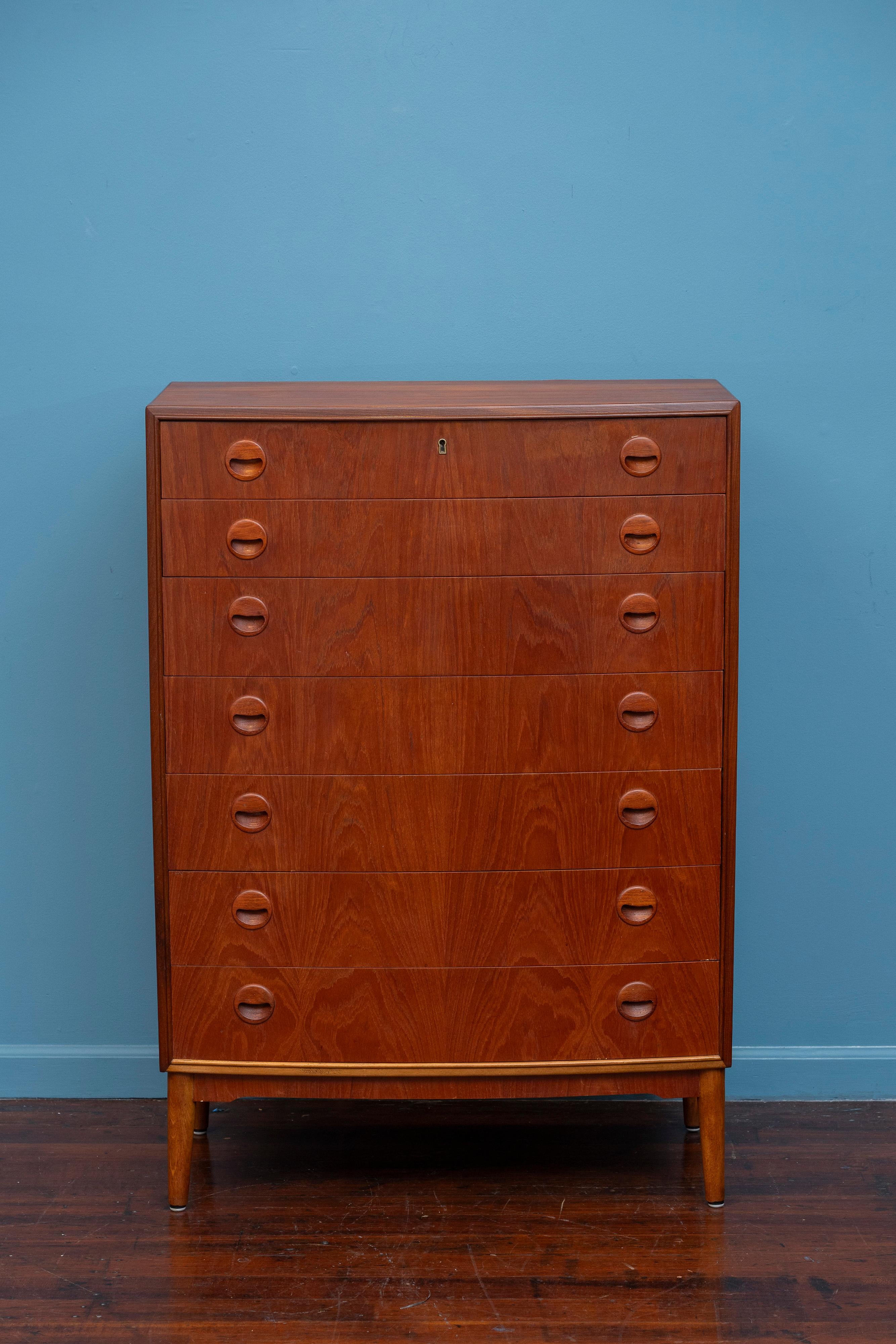 Comò alto in teak con sette cassetti, design Kai Kristiansen. Costruzione e materiali di alta qualità realizzati da uno dei designer scandinavi di maggior successo. Sette cassetti in legno di teak con tiretti a forma di coppa. Pronto per essere