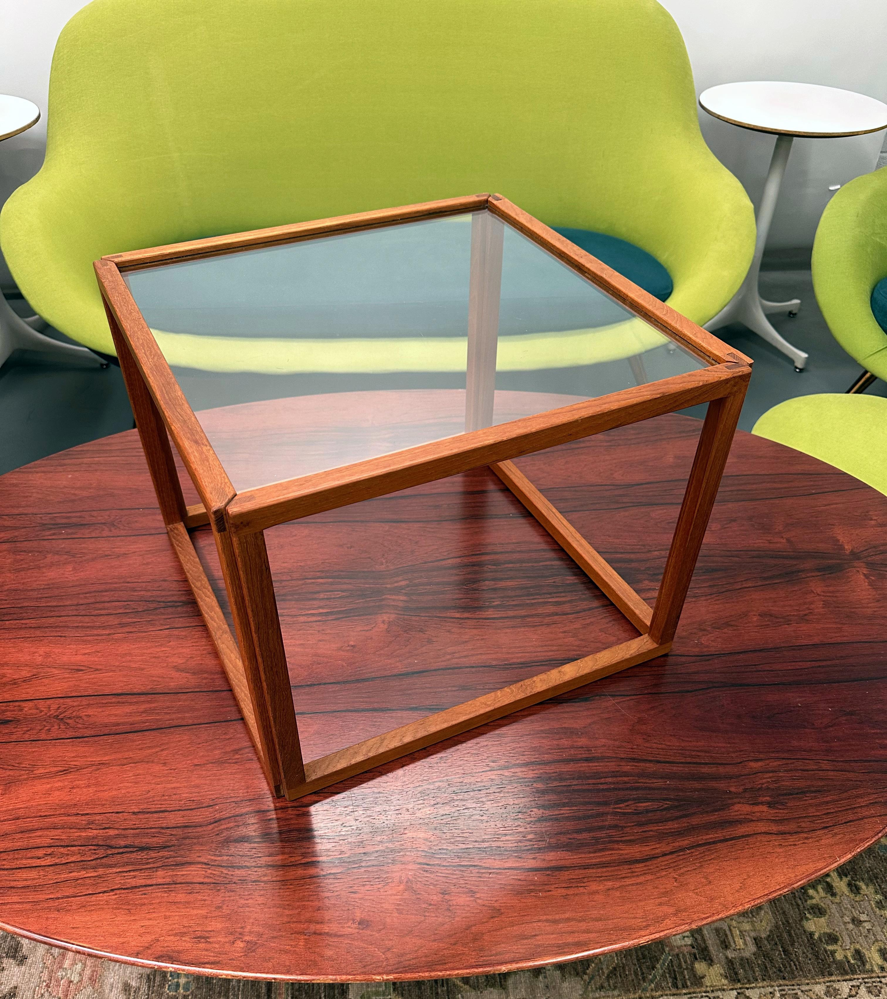 Design minimaliste emblématique du maître danois Kai Kristiansen, cette rare table d'appoint cubique incarne les lignes épurées et l'élégance architecturale du modernisme du milieu du siècle dernier. Fabriquée au Danemark à la fin des années 1950 ou