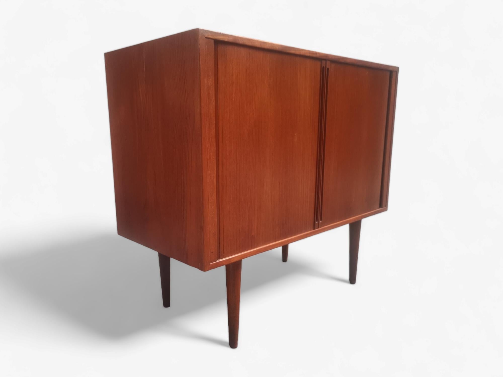 This Teak cabinet is designed by Kai Kristiansen for the FM System (Feldballes Møbelfabrik) in the 60s. 

Cabinet are with dual tambour doors, and 2 adjustable drawers.

