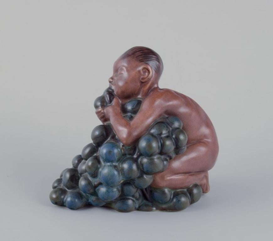 Danish Kai Nielsen for Bing & Grøndahl. Stoneware figurine. Little Bacchus with Grapes. For Sale