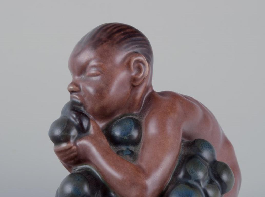 Kai Nielsen for Bing & Grøndahl. Stoneware figurine. Little Bacchus with Grapes. In Excellent Condition For Sale In Copenhagen, DK