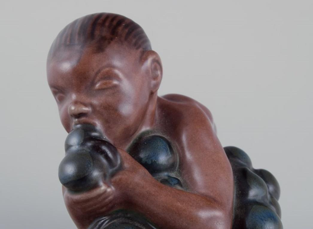 Kai Nielsen for Bing & Grøndahl. Stoneware figurine. Little Bacchus with Grapes. For Sale 1