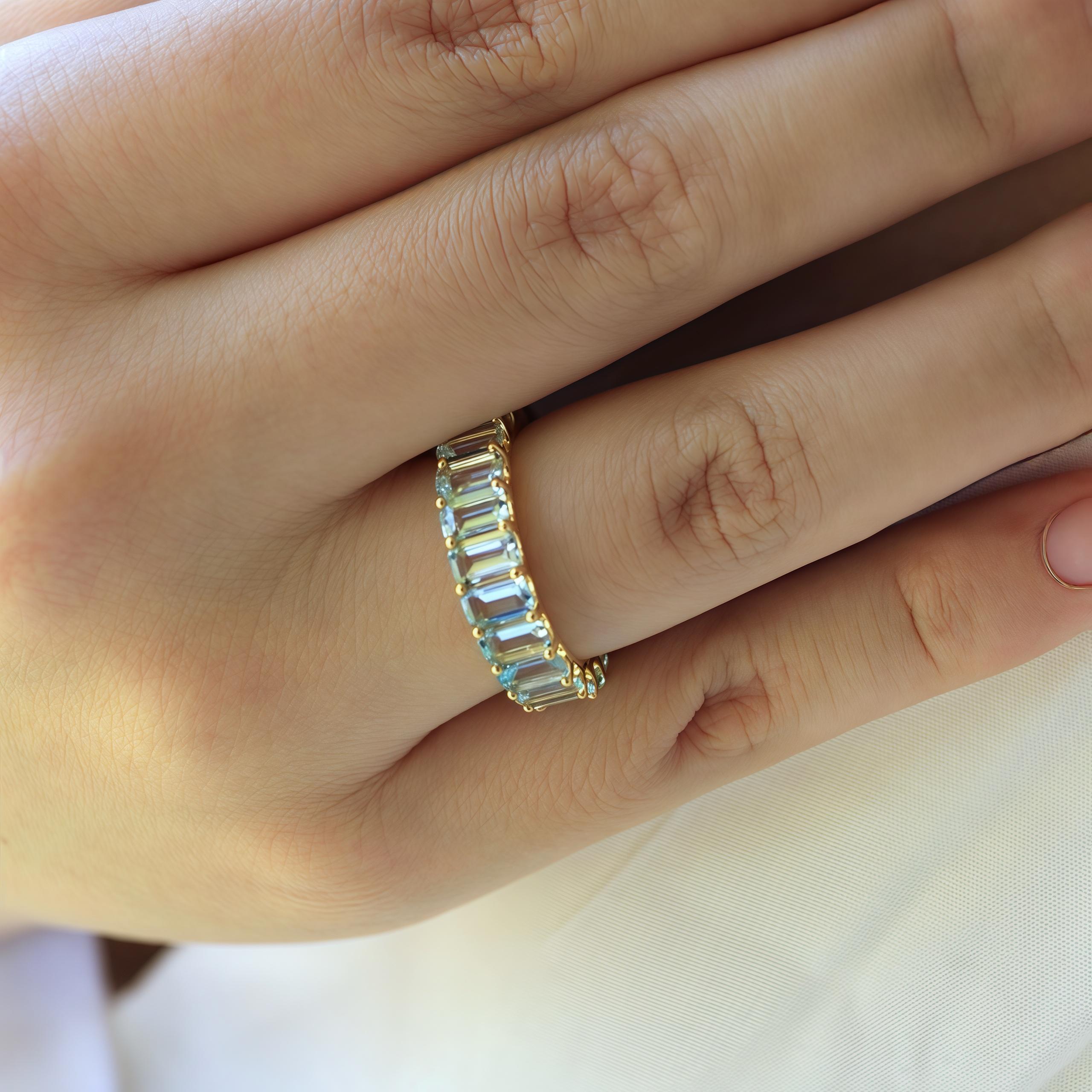 The Eternity Angel Blue Emerald-Cut Aquamarine Ring is a breathtaking blend of classic elegance and modern charm. With exquisite emerald-cut aquamarines encircling your finger, this ring creates a seamless halo of serene sky-blue beauty. The solid