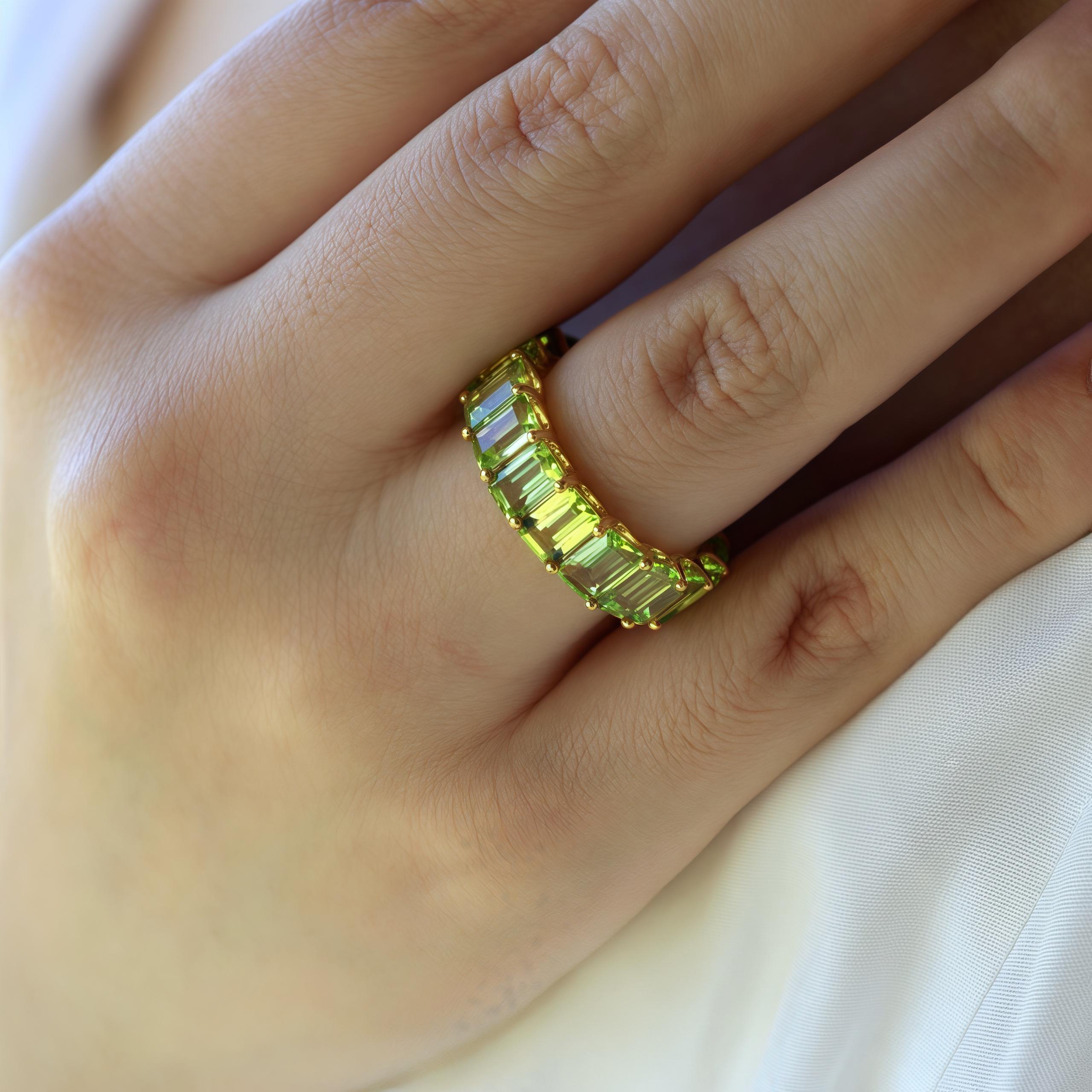 The Eternity Peacock Green Emerald-Cut Peridot Ring is a stunning piece that combines classic elegance with modern sophistication. This ring features vibrant emerald-cut peridots that encircle your finger, creating a continuous line of dazzling