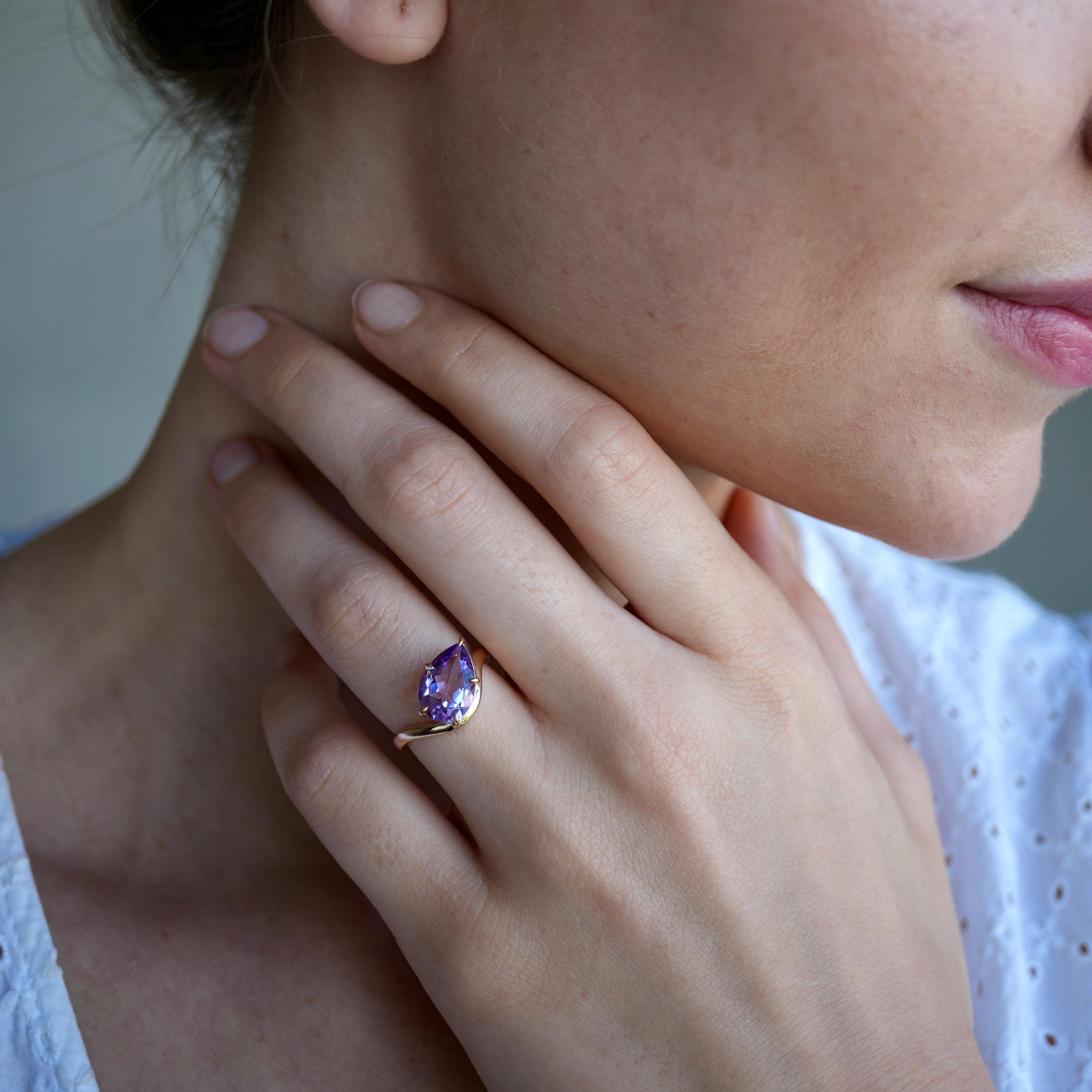 Set in 14K rose gold, this East-West ring features a vibrant pear-cut amethyst, embraced by flowing, wave-like lines that echo the calm rhythm of the sea. The gemstone’s brilliance shifts with every glance—soft yet striking, like twilight reflected