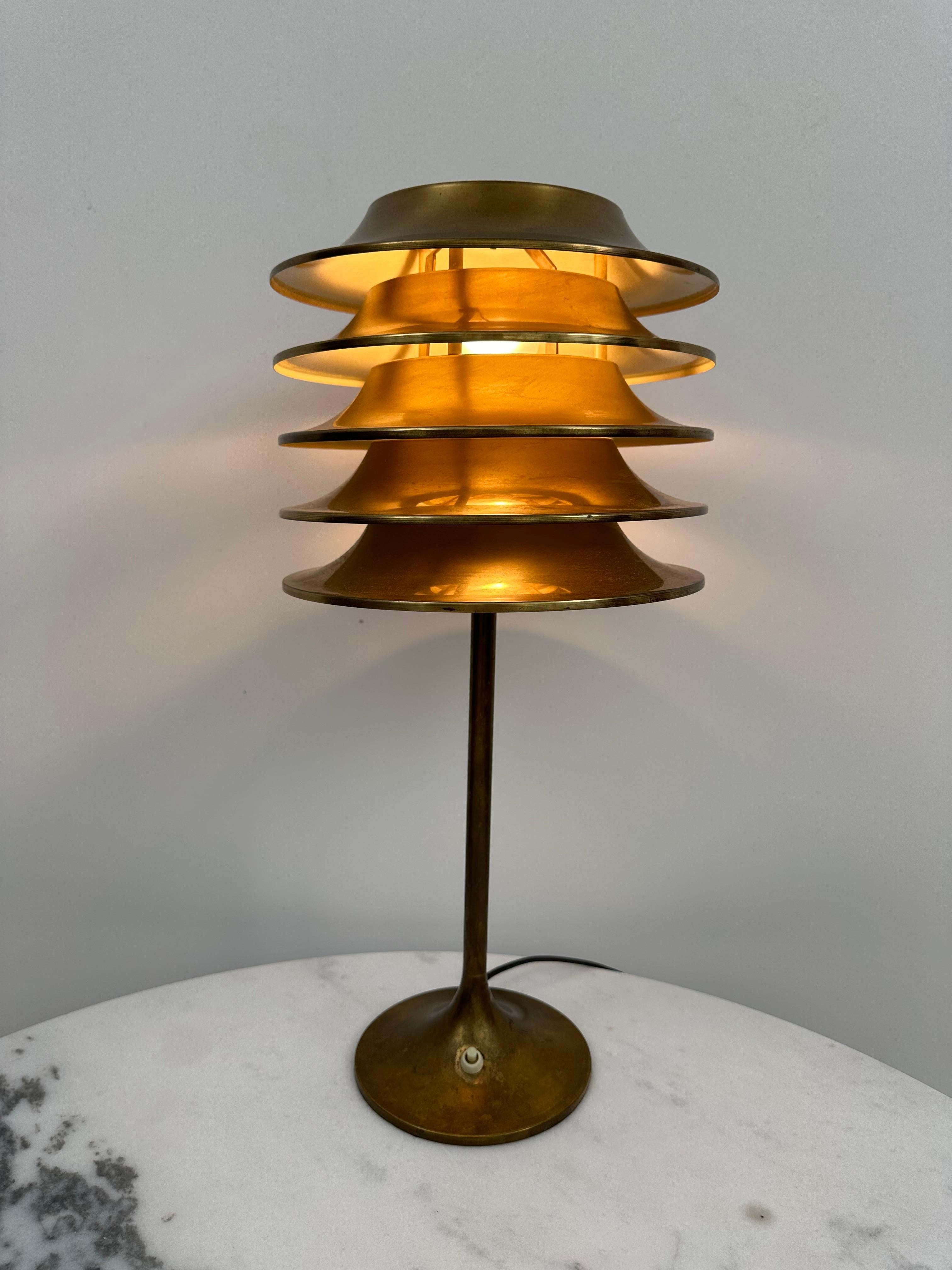 The lamp is designed by renowned Finnish Designer Kai Ruokonen and manufactured by Sieva Oy in the 70's.  

The lamp is made of brass with a beautiful patina and it remains unpolished as wanted by the designer. There is something magical about the
