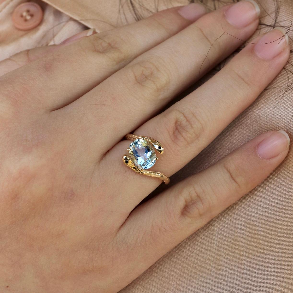 The Kai Snake Aquamarine Sapphire East-West Ring in 14K solid gold is a bold symbol of elegance, mystery, and refined luxury. Featuring a mesmerizing natural aquamarine, this ring showcases the gemstone in an east-west setting, emphasizing its