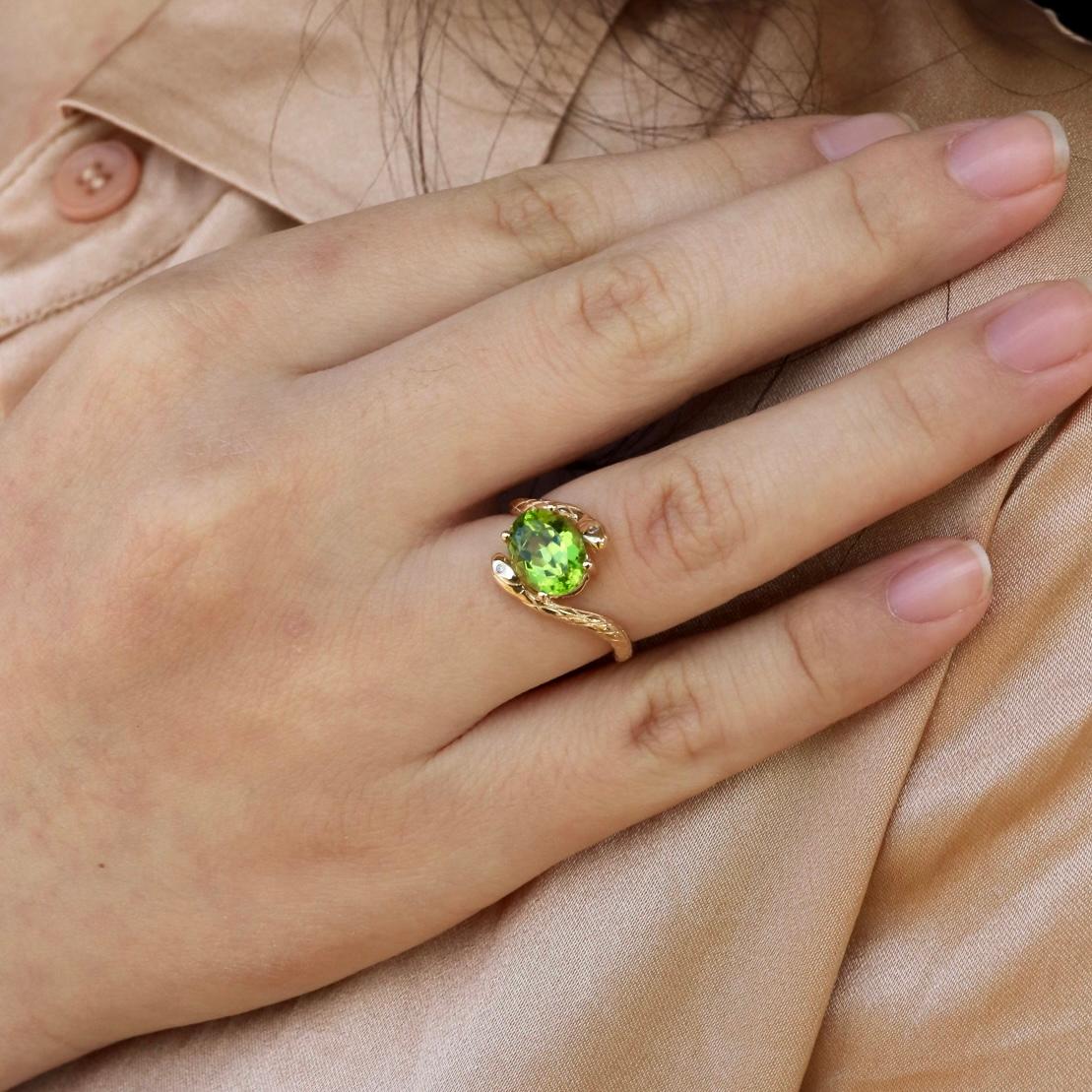 Unleash the vibrant beauty of nature with the Kai Snake 2.12 ctw Peridot Diamond East-West Ring in 14K Solid Gold. At its heart, a striking natural peridot gemstone takes center stage, its vivid green hue enhanced by a unique east-west setting. The