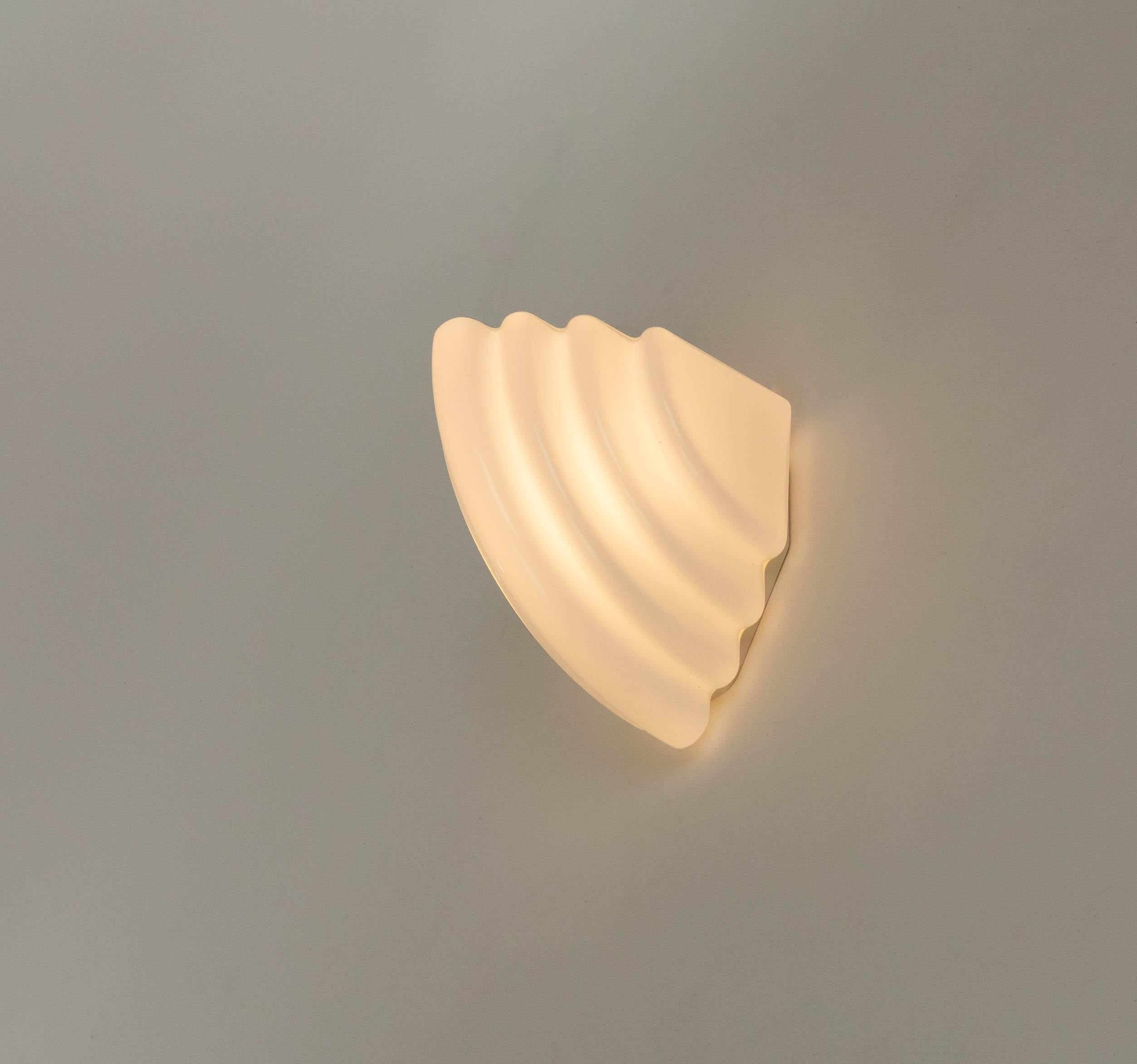 Kai wall lamp designed by Kazuhide Takahama in 1985 and produced by Sirrah.

The model consists of an opaline glass shade and a plastic suspension base. Later versions of this model were made of acrylic and of metal.

The half bowed Kai can be