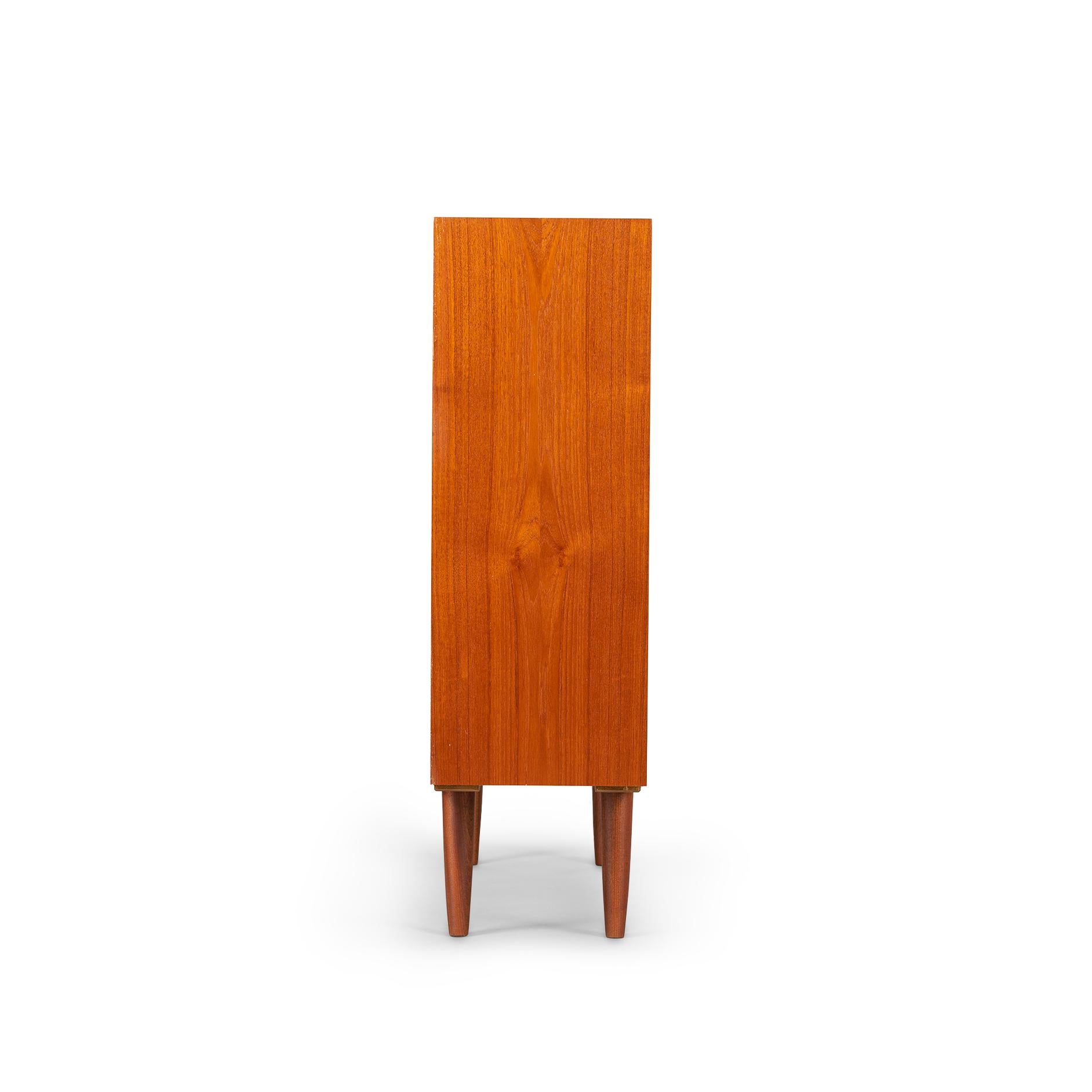 Nice elegant bookcase in teak by design of Kaj Winding for Poul Jeppesens Møbelfabrik from the 1960s. Four truly beautifully crafted hardwood drawers with signature Winding grips line the top of the bookcase which further comprises four height