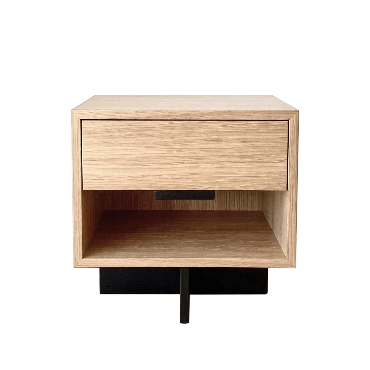 Kaid nightstand is a functional and eye-catching furniture piece that is sure to add a modern and unique touch to your living space.

The contrast between the massive, rectangular storage component and the thin, linear pedestal results in a light