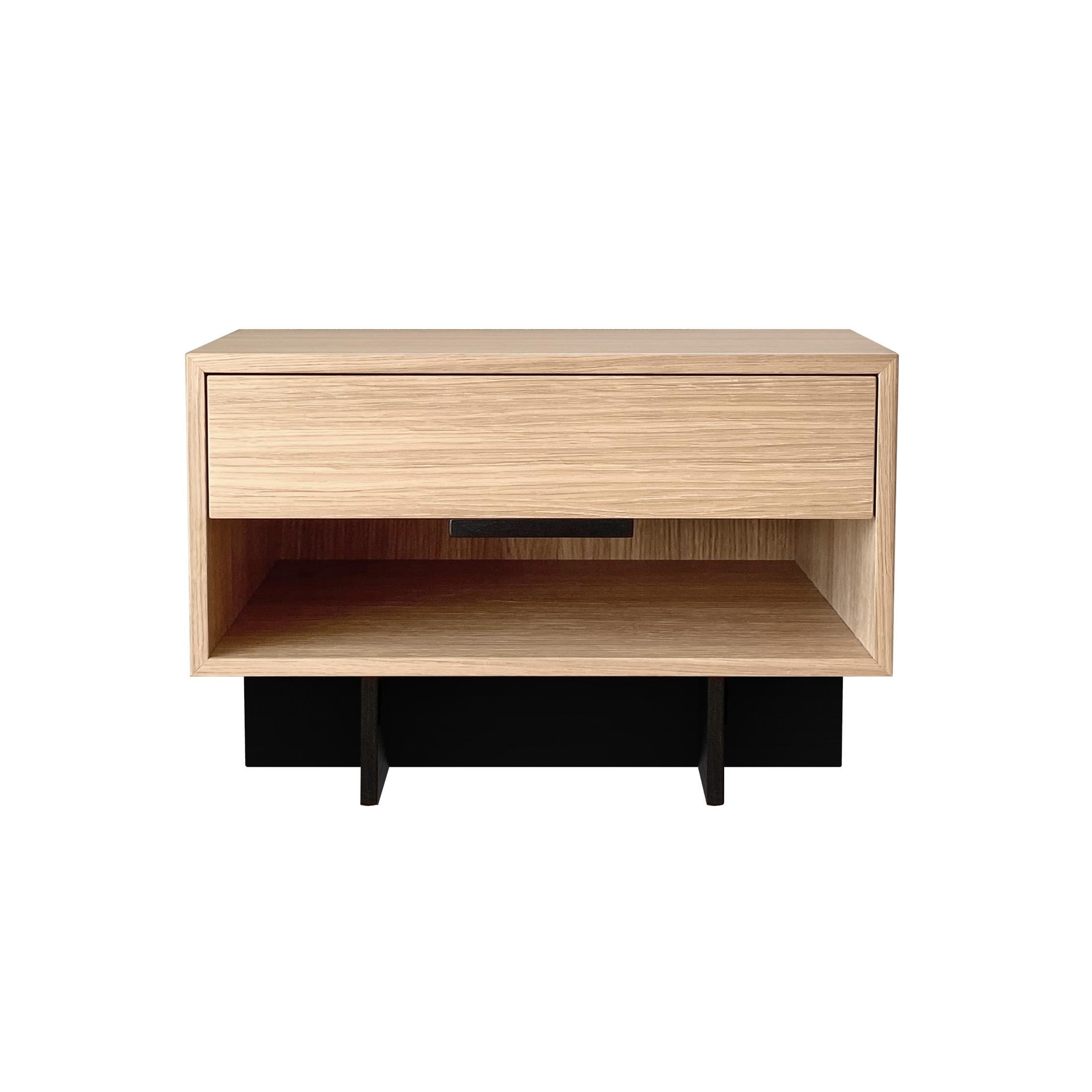Kaid nightstand is a functional and eye-catching furniture piece that is sure to add a modern and unique touch to your living space.

The contrast between the massive, rectangular storage component and the thin, linear pedestal results in a light