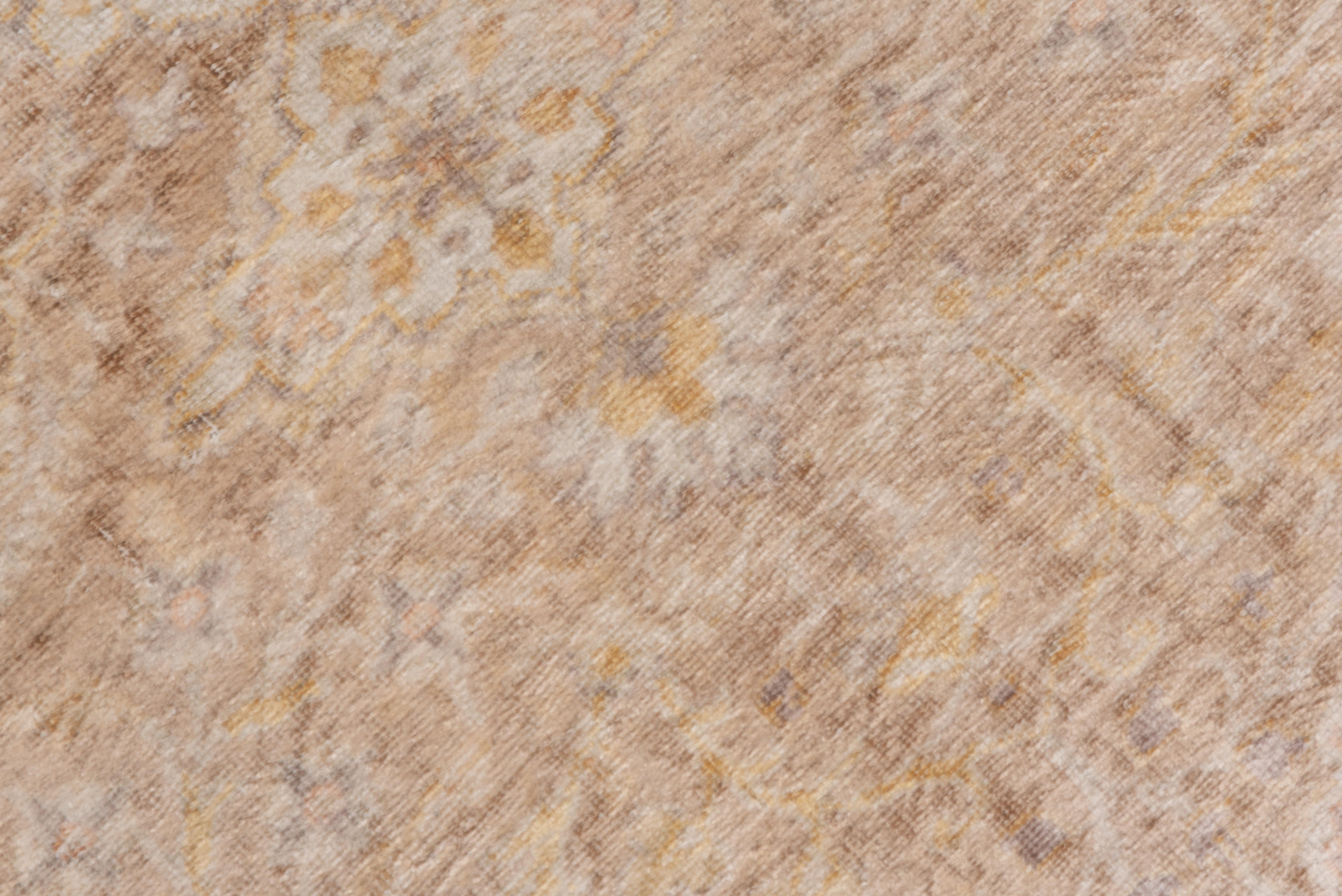 The rusty-buff ground of this eastern Turkish town scatter supports a lobed ivory and straw medallion, with floral arabesque field decor and slate corners with double straw internal pendants. The sand border shows a double recurved split leaf