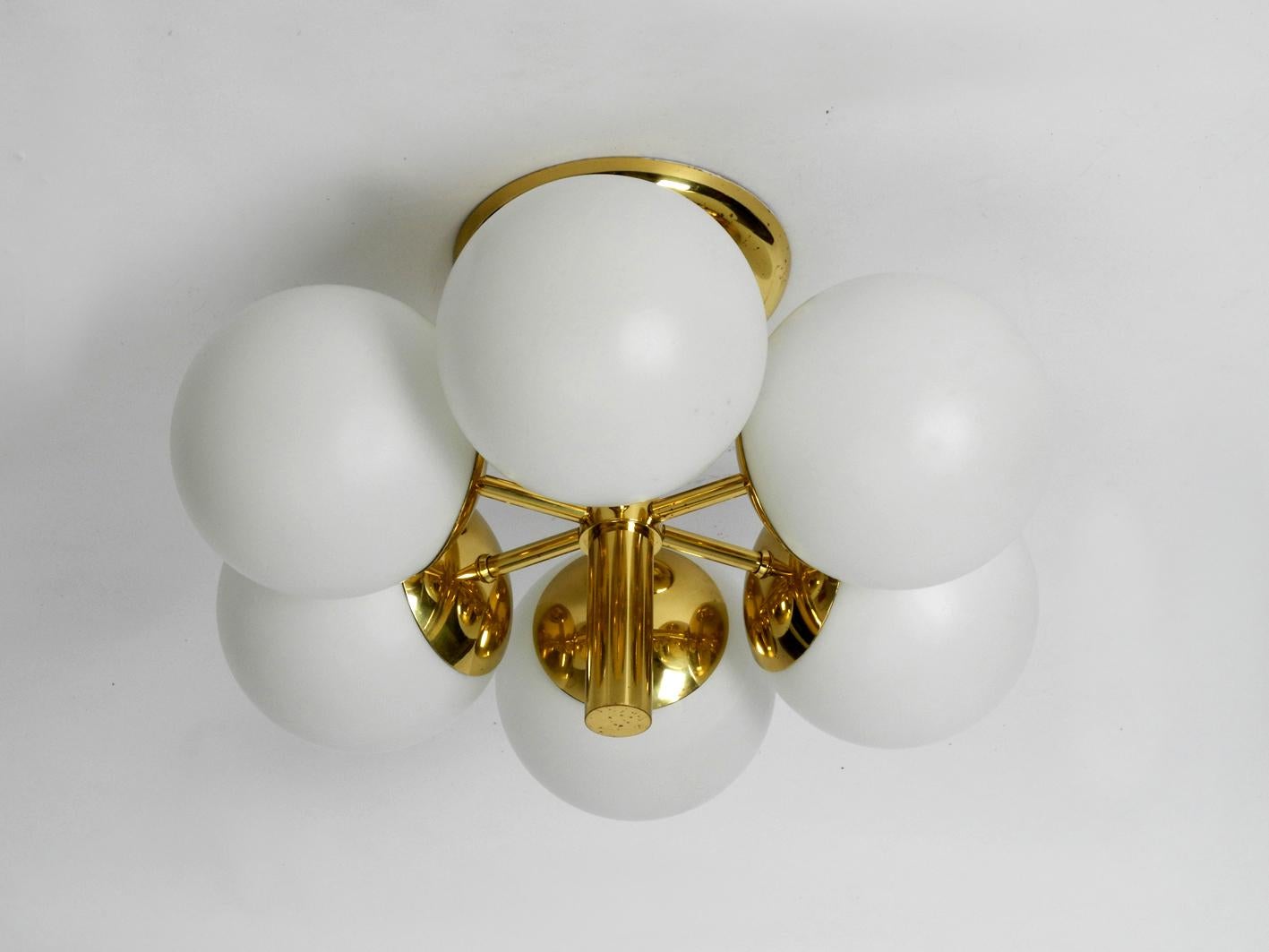 Beautiful Kaiser brass ceiling lamp with six opaline glass balls in white. Elegant sixties Space Age Atomic Design. Very good vintage condition without damages. Very few signs of wear. The brass has some very nice patina, which the pictures shows