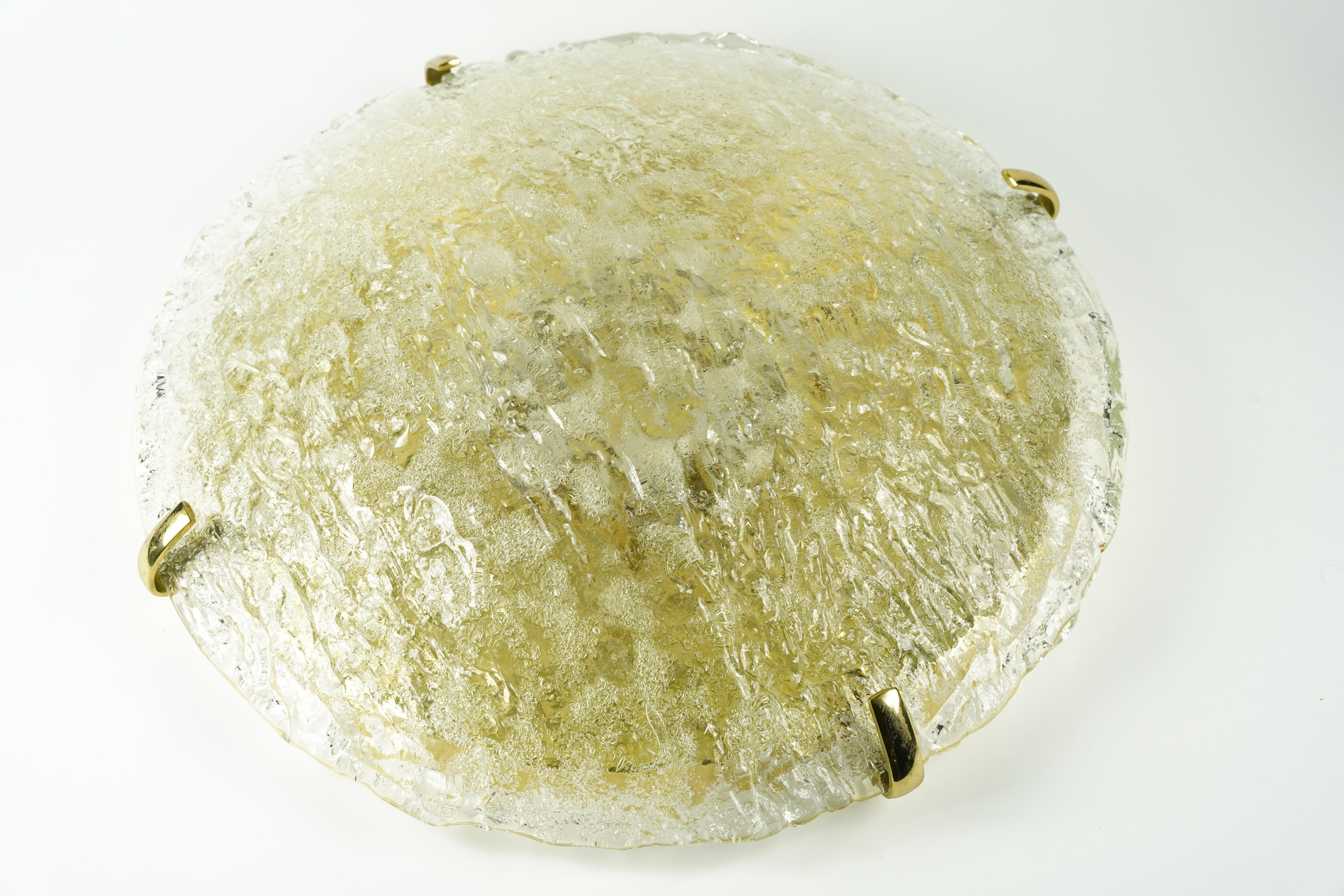 Flushmount by Kaiser, Allemagne, 1970 un diffuseur rond en verre clair en forme de dôme en verre épais et lourd qui est lisse à l'extérieur et mat à l'intérieur quatre épis de faîtage en laiton, huit douilles européennes sur un cadre en laiton.
