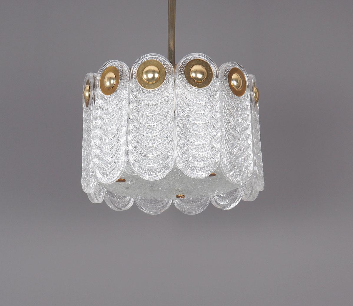 Vintage hanging lamp from Kaiser Leuchten Germany. Produced in the 60s. The lamp is made up of elongated discs of ribbed crystal glass with a crystal glass cover at the bottom and a brass plate at the top. The glass discs are fixed with round brass