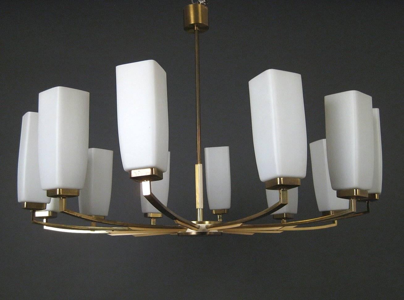 Beautiful large chandelier made by Kaiser Leuchten in the 1960s. Construction with brass rods, partly with creamy applications, opaline glass shades, equipped with twelve E14 sockets. Marked with sticker.
Measures: Diameter about 95cm, height about