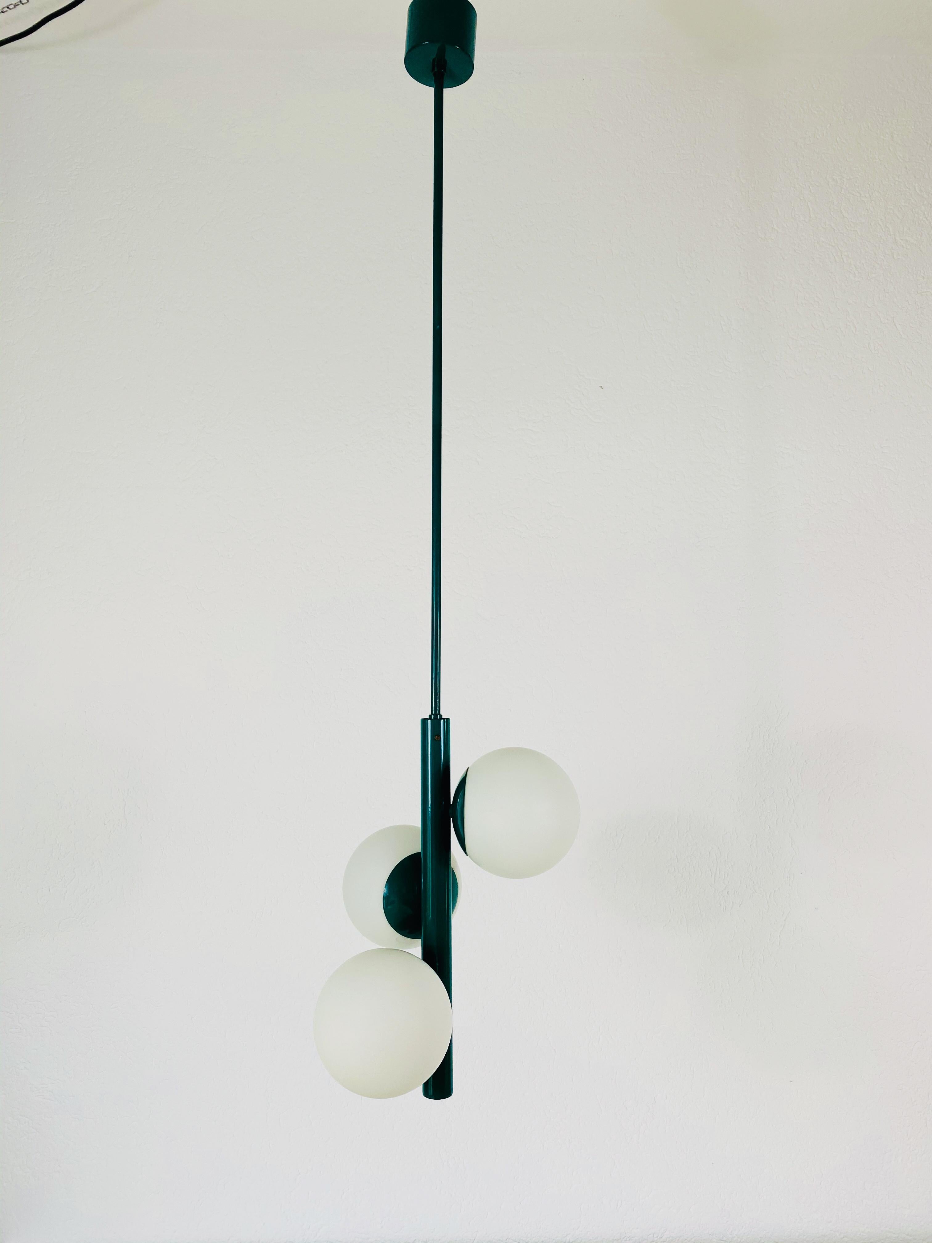 A midcentury chandelier by Kaiser made in Germany in the 1960s. It is fascinating with its Space Age design and three opaque balls. The body of the light is made of full metal, including the arms.


The light requires three E14 light bulbs. Very