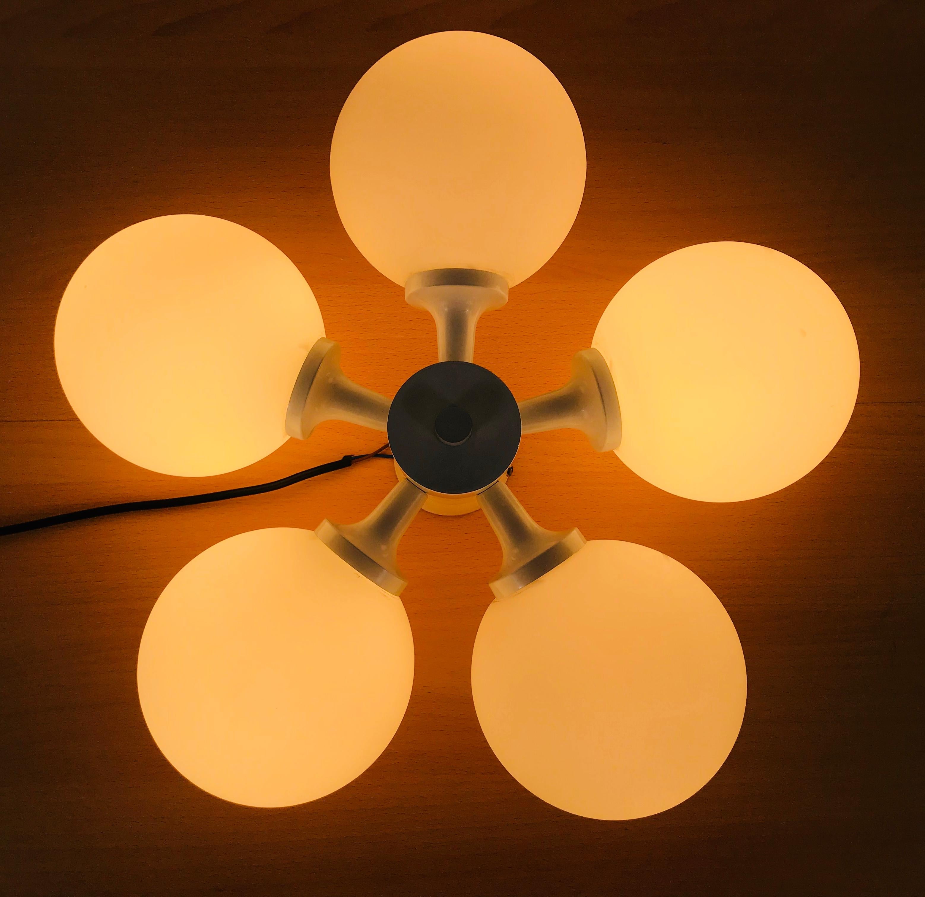 A midcentury flush mount by Kaiser made in Germany in the 1960s. It is fascinating with its Space Age design and five opaque balls. The white circular body of the light is made of full metal, including the arms.


The light requires five E14