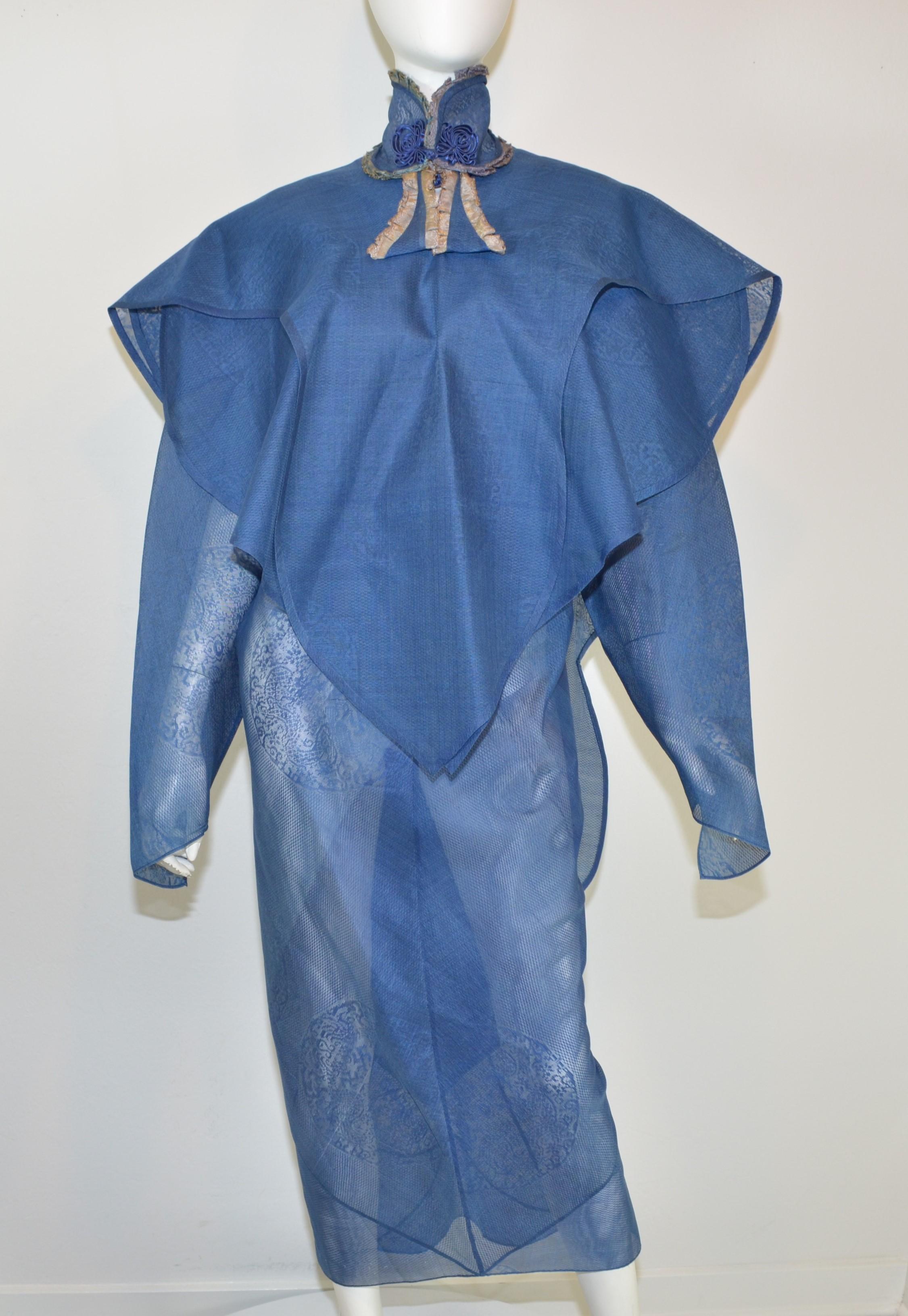 This ensemble is featured in a blue organza jacquard fabric and has several layers as pictured ( dress, 2 apron layers, and a neck piece.) Dress (which is the base layer) has embroidered frog closure buttons at the opening of the neck, cutout detail