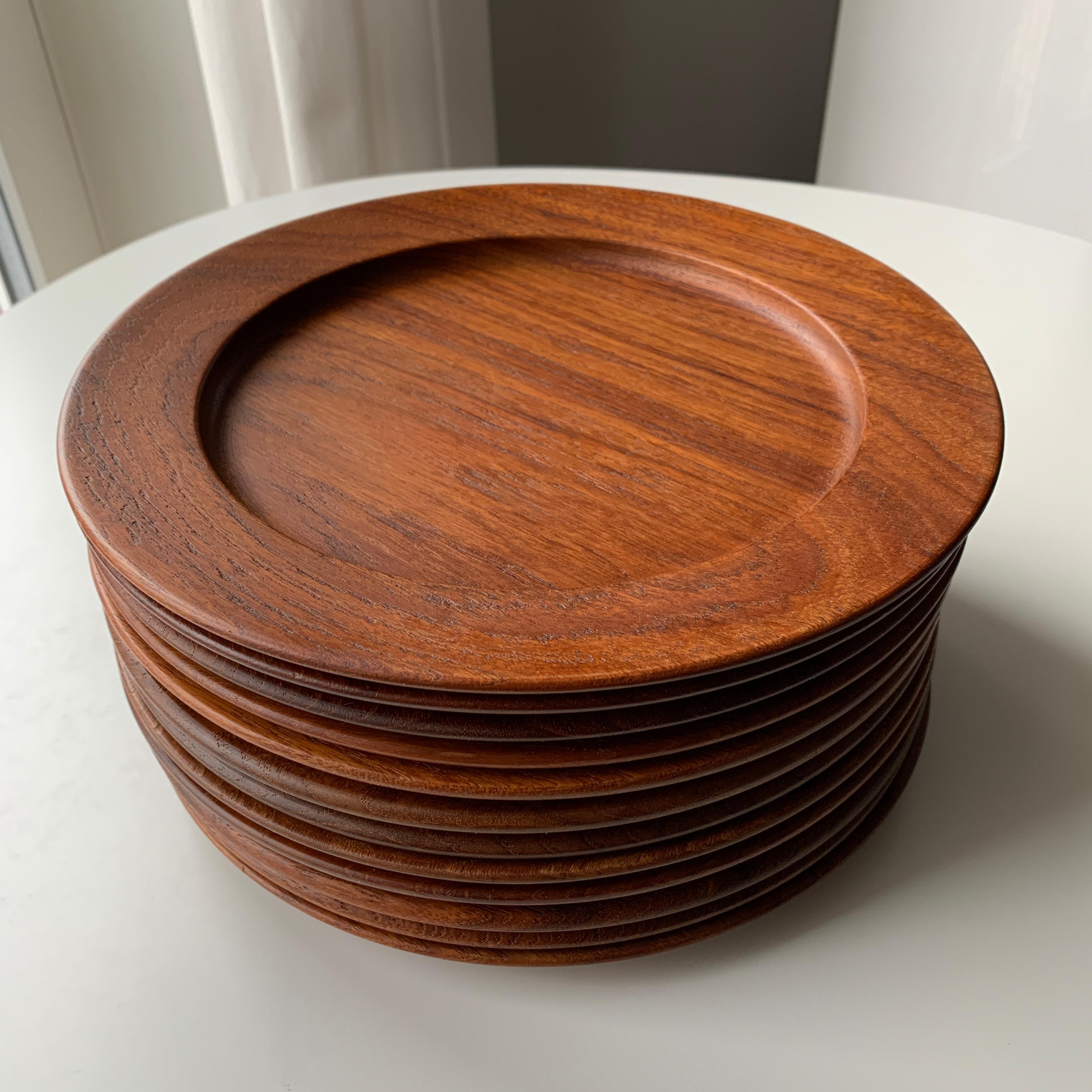 Kay Bojesen midcentury 12 solid teak serving dishes. Scandinavian Modern Danish design. Each plate with Kay Bojesen Denmark teak logotype. Each plate is unique in the appearance due to the nature of the wood. Some plates with more rough structure