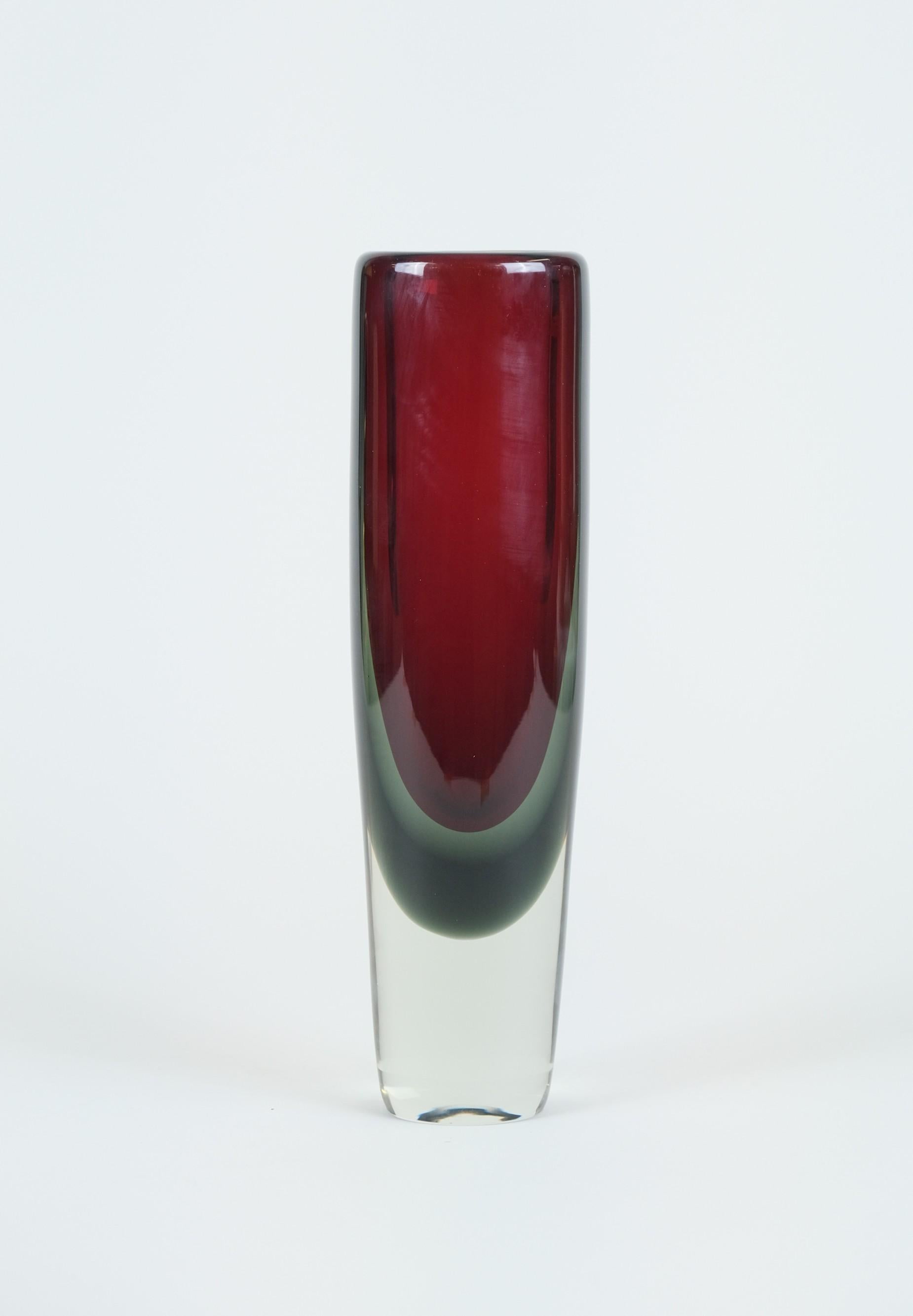 Ce magnifique objet d'art soufflé librement a été réalisé dans un certain nombre de tailles et de formes différentes. Cet exemple est le plus grand, de couleur rouge rubis, entouré d'un rideau gris. D'une beauté étonnante avec la lumière du soleil,