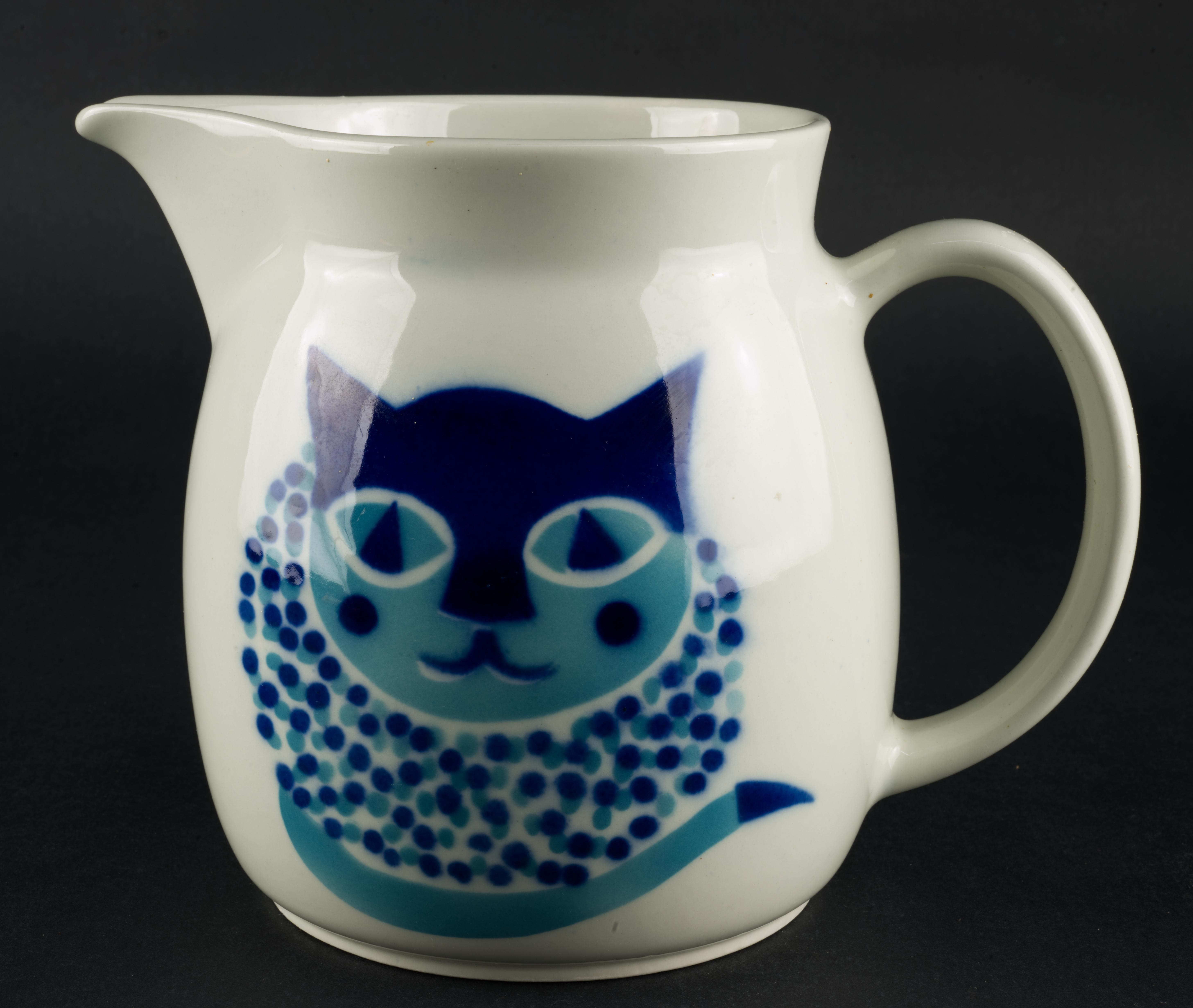  Playful Mid Century Modern Kissa KL2 pitcher with blue cat decor was made as a part of a series, with decor designed by Gunvor Olin-Grönqvist and pitcher shape created by Kaj Franck for Arabia Finland in 1969. Kissa series consists of four ceramic