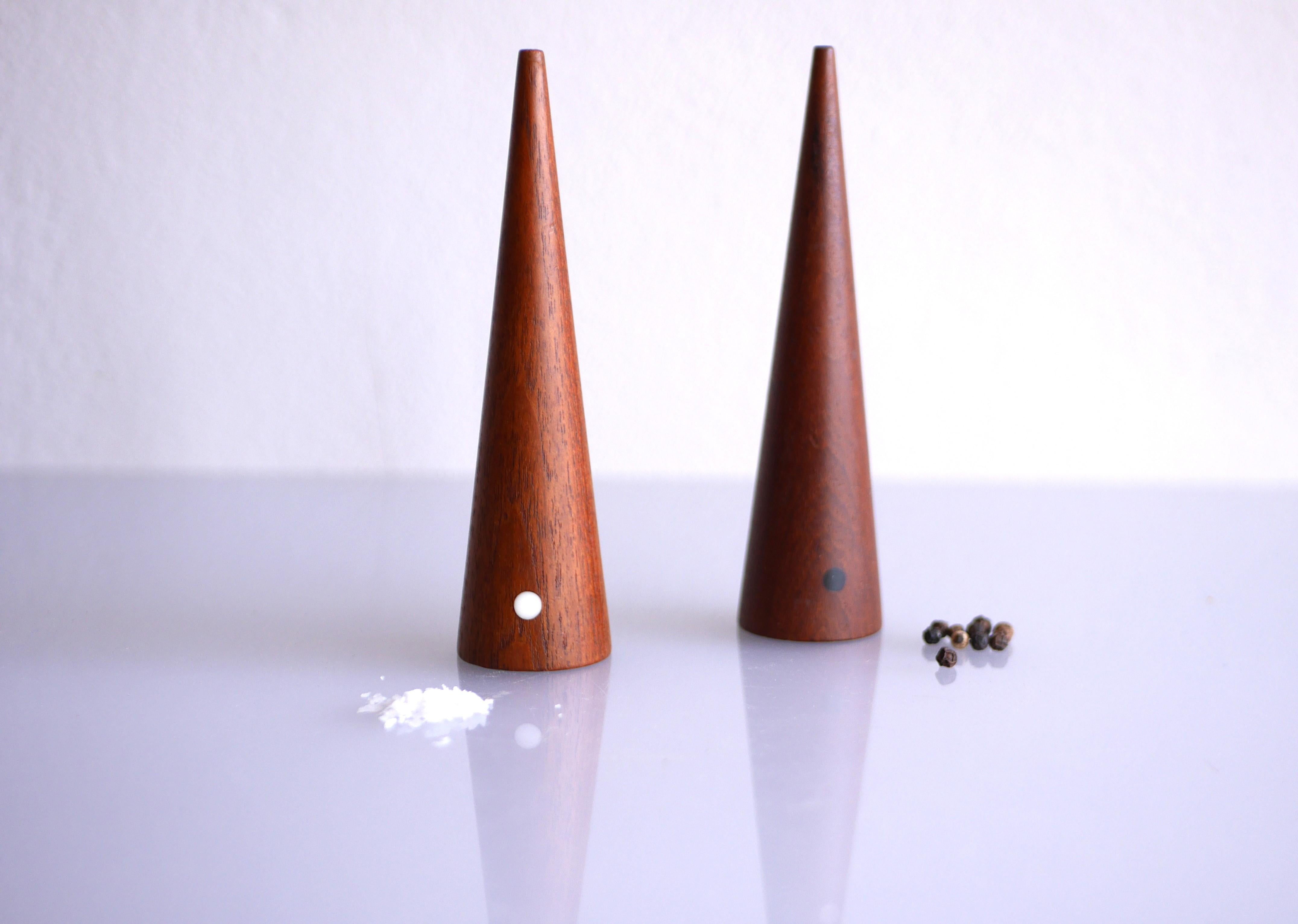 A pair of iconic vintage teak salt and pepper shakers, design by the talented Kaj Franck. These shakers are very much of their time, late 60s, yet it is the design, simple cone shaped, with a little white and black dot for salt and pepper. It is the