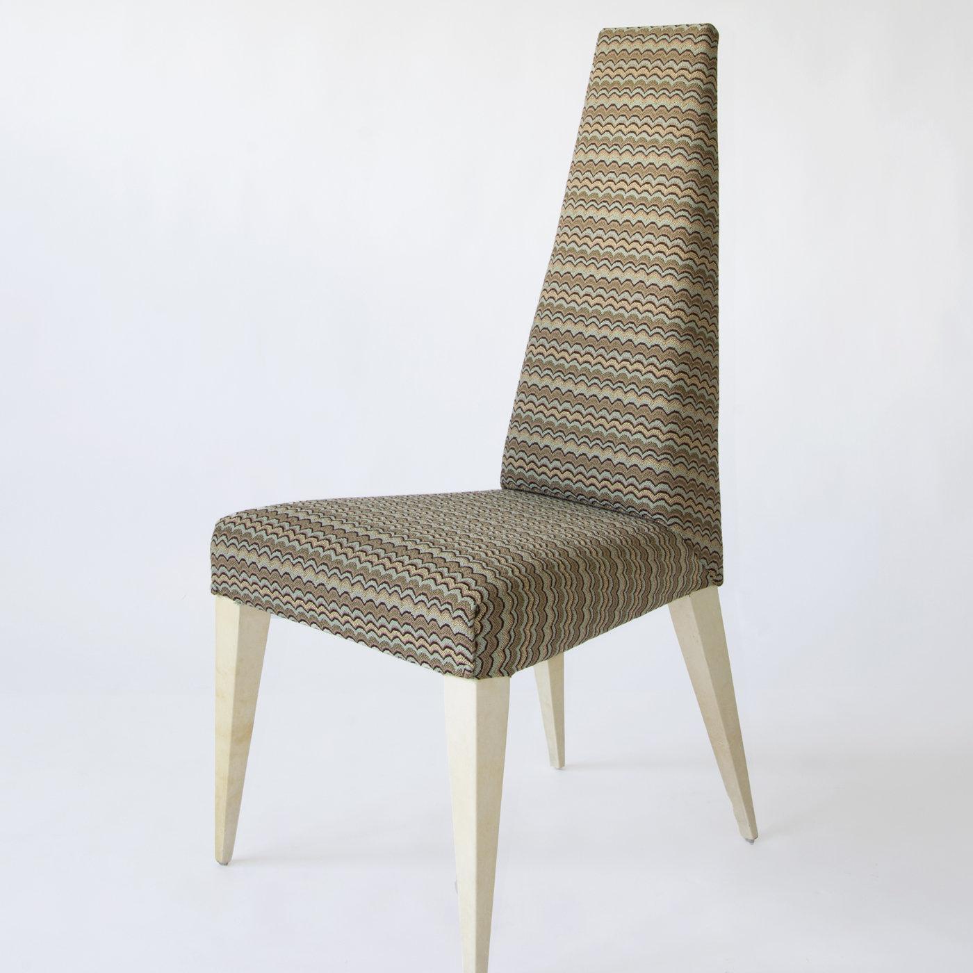 With sleek lines and a unique design, the Kajal Dining Chair features sturdy, tapered legs covered with natural light-toned parchment for a sophisticated and elegant look. Upholstered in a multicolor fabric that features a subtle pattern in neutral