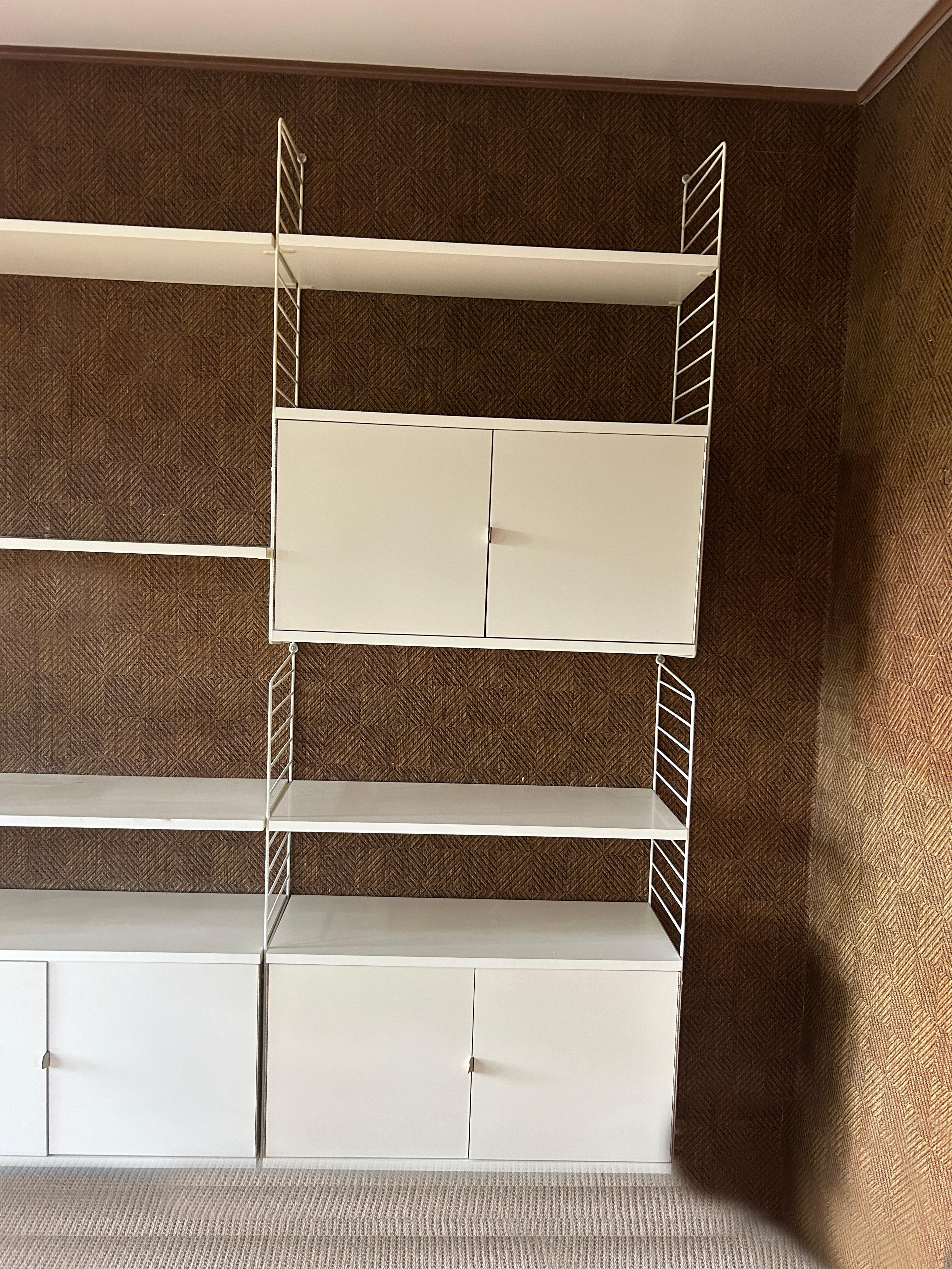 Mid century Kajsa & Nisse Strinning White Laminate 4 bay String wire wall unit circa 1970 Sweden. Great unit very high end laminate with chrome hinges and white leather pulls. Has all hardware in tack. Great mid century Swedish wall unit. 

This