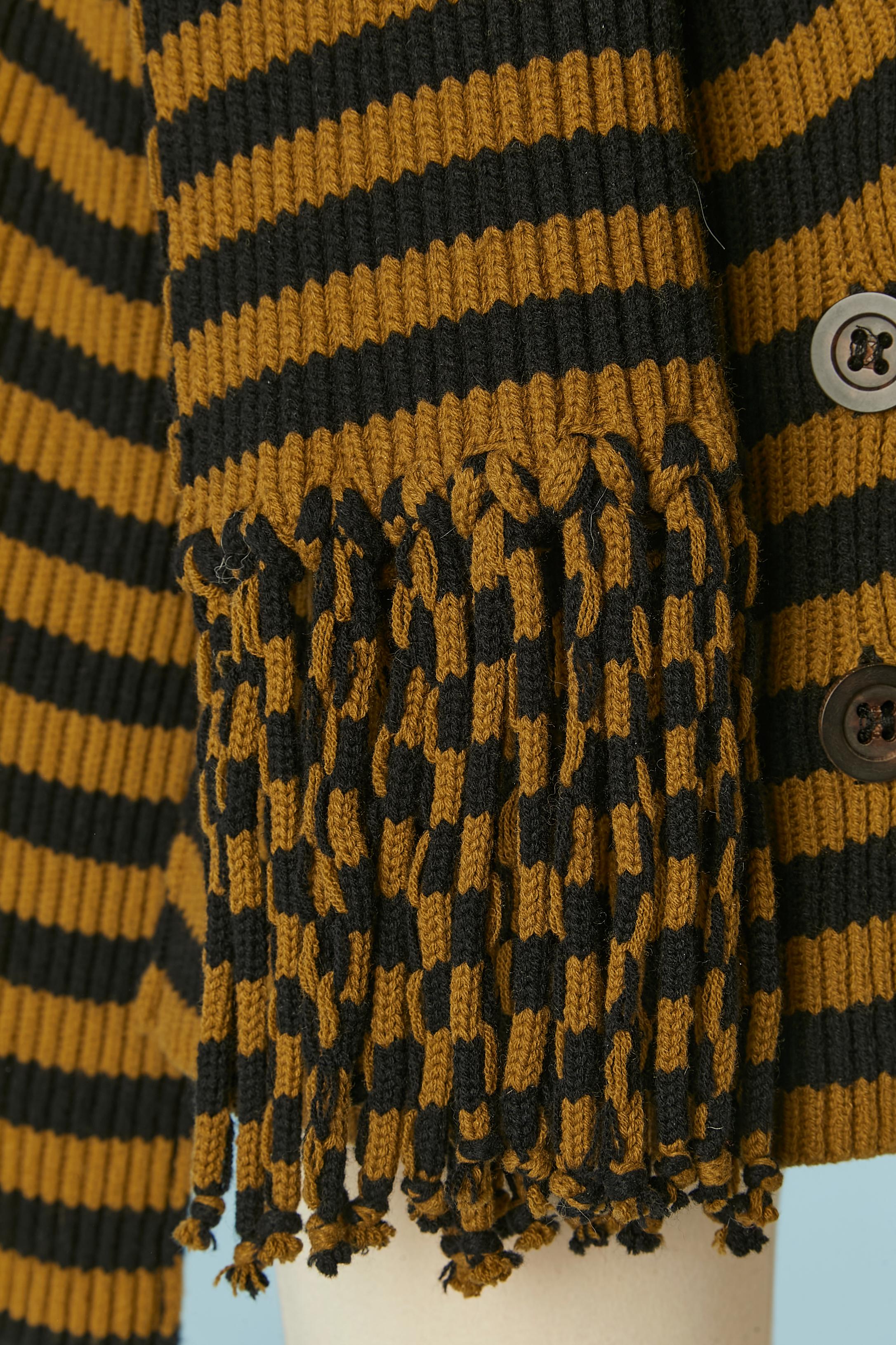 Gilet rayé kaki et noir en laine (90%) et cachemire (10%) avec écharpe.
Fermeture par bouton et boutonnière sur le milieu du devant. 
TAILLE 40 / M-ONE 