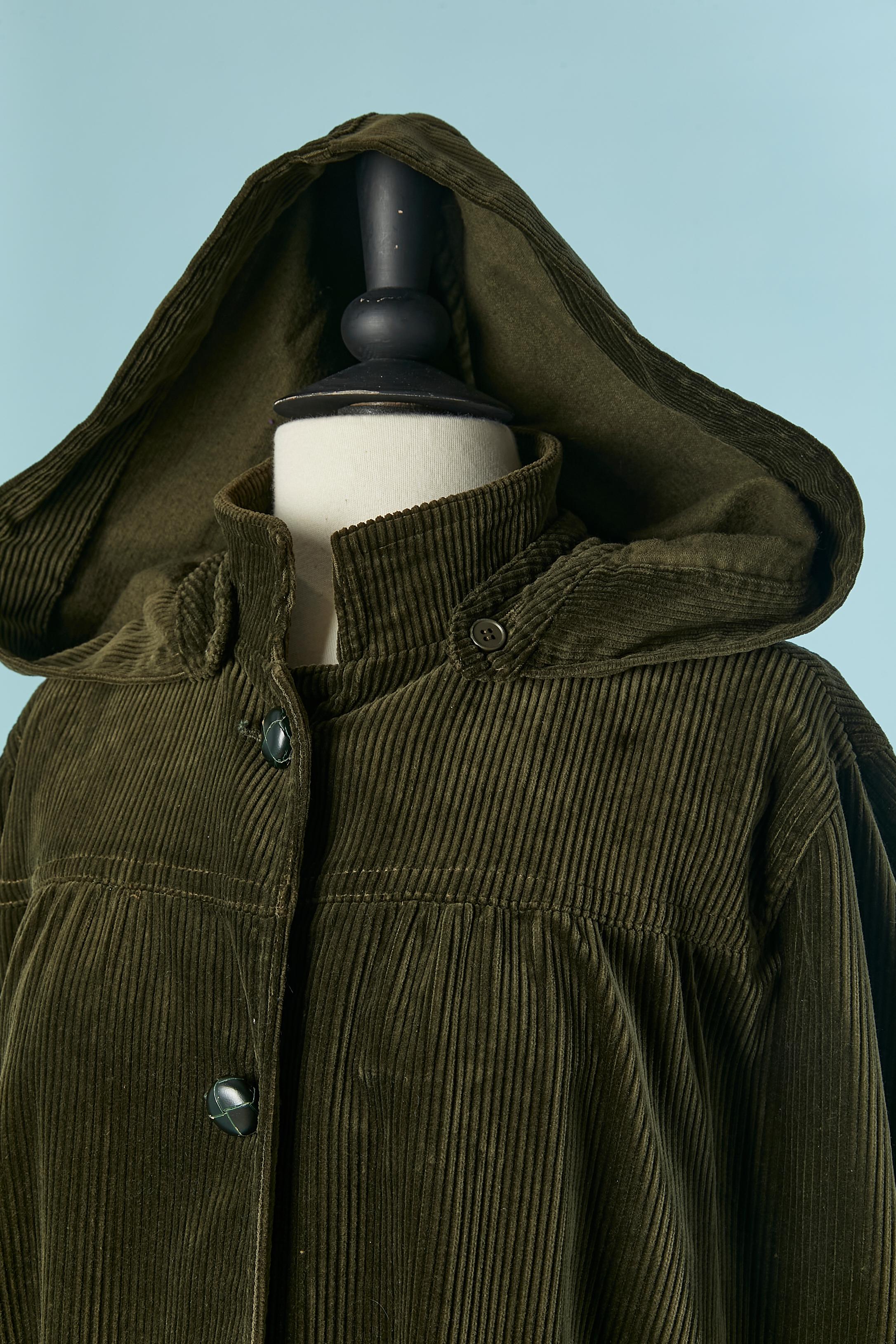 Kaki cotton Corduroy cape with hood. no fabric composition tag for the lining but it's probably acetate or rayon. Detachable hood with button and buttonhole. Leather button and buttonhole closure on the middle front. 
SIZE M/L 