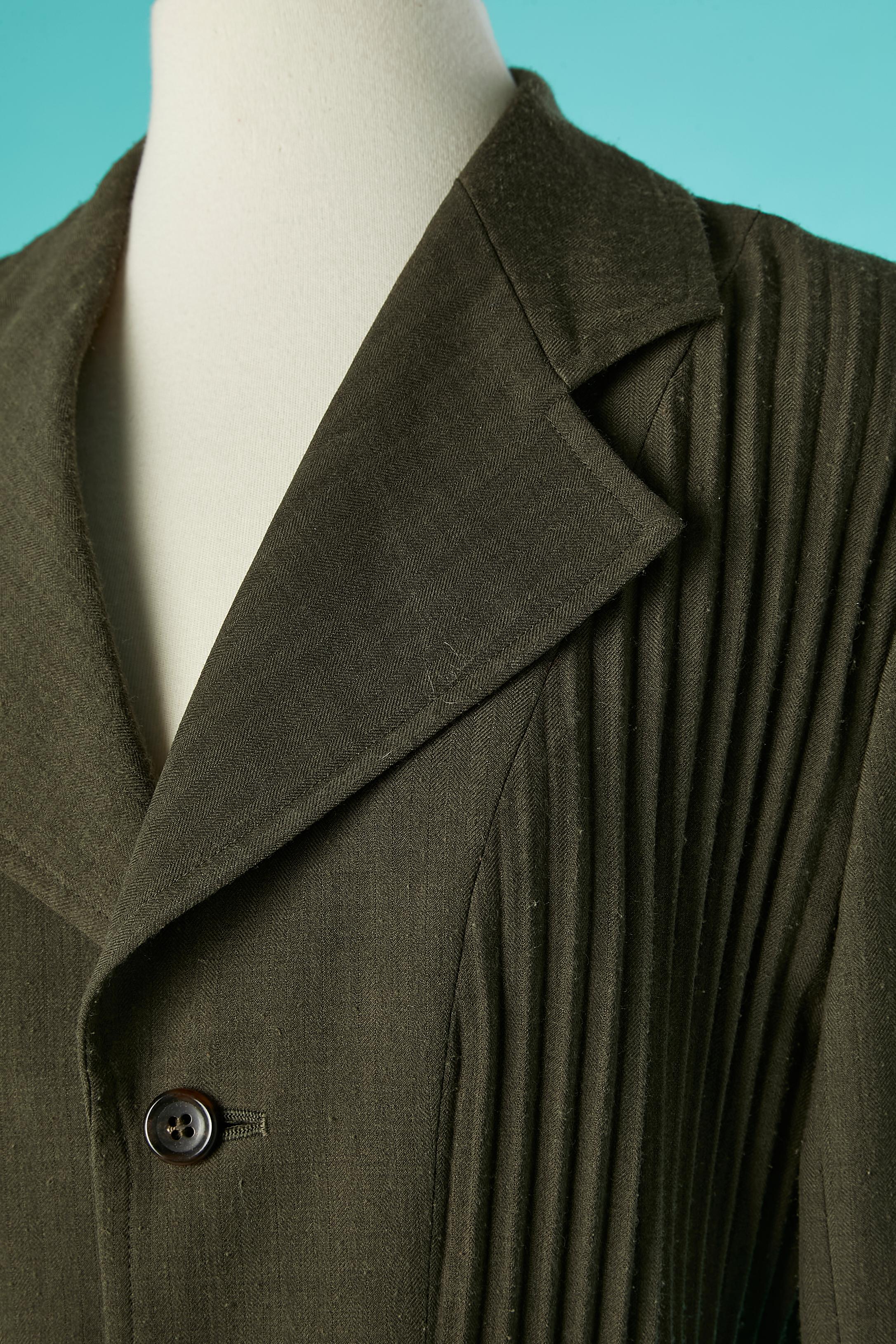 Veste Kaki à simple boutonnage avec plis soleil et ceinture. Pas d'étiquette de tissu mais probablement une doublure en laine et acétate ( seulement à l'intérieur des épaules et des manches). 
TAILLE ( pas d'étiquette) mais taille L 