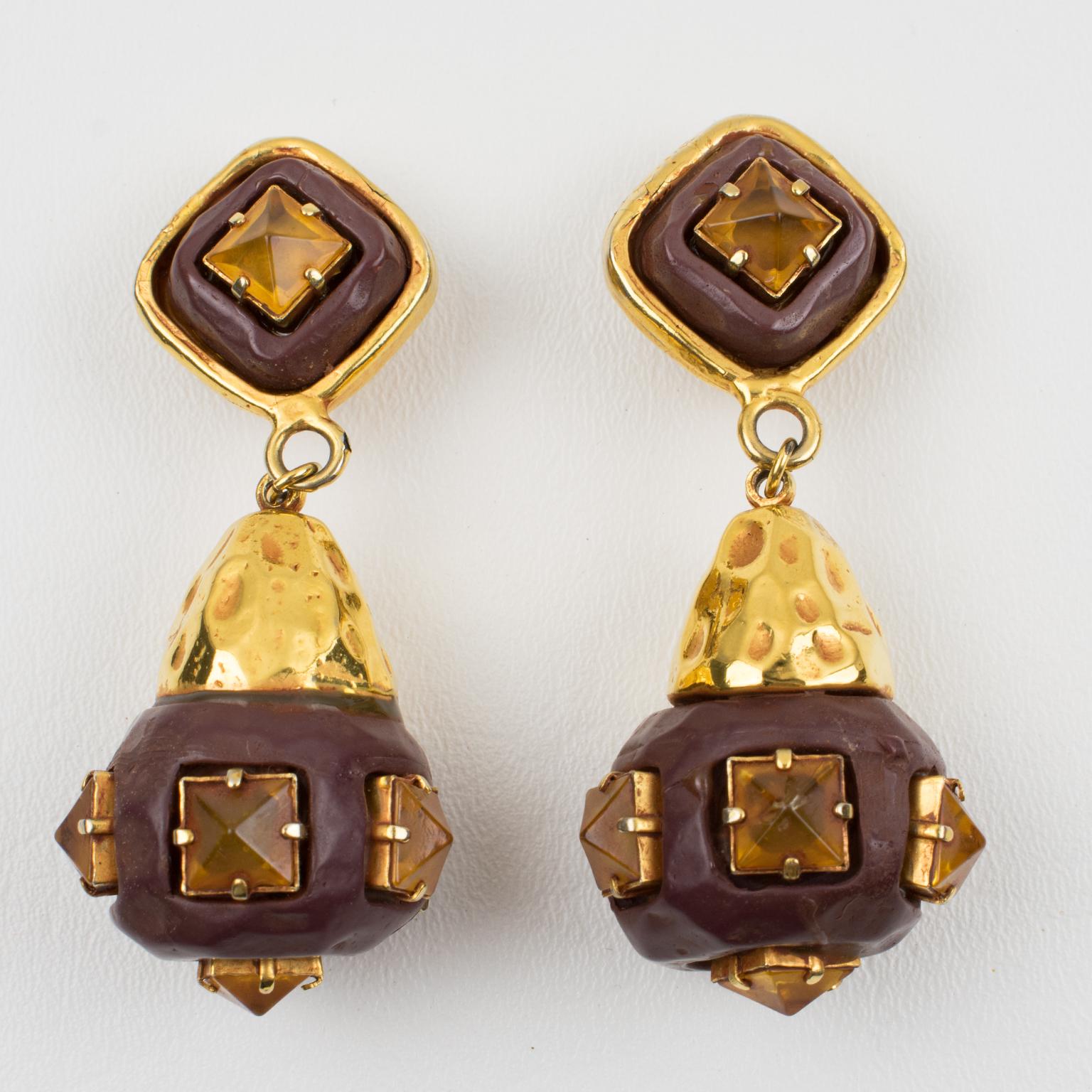 Elegant Kalinger Paris dangling clip-on earrings. Oversized geometric shape featuring gilt metal framing and a large dangle ball in chocolate resin imitating wood all carved and textured topped with amber-colored resin rhinestones. 
Company marking