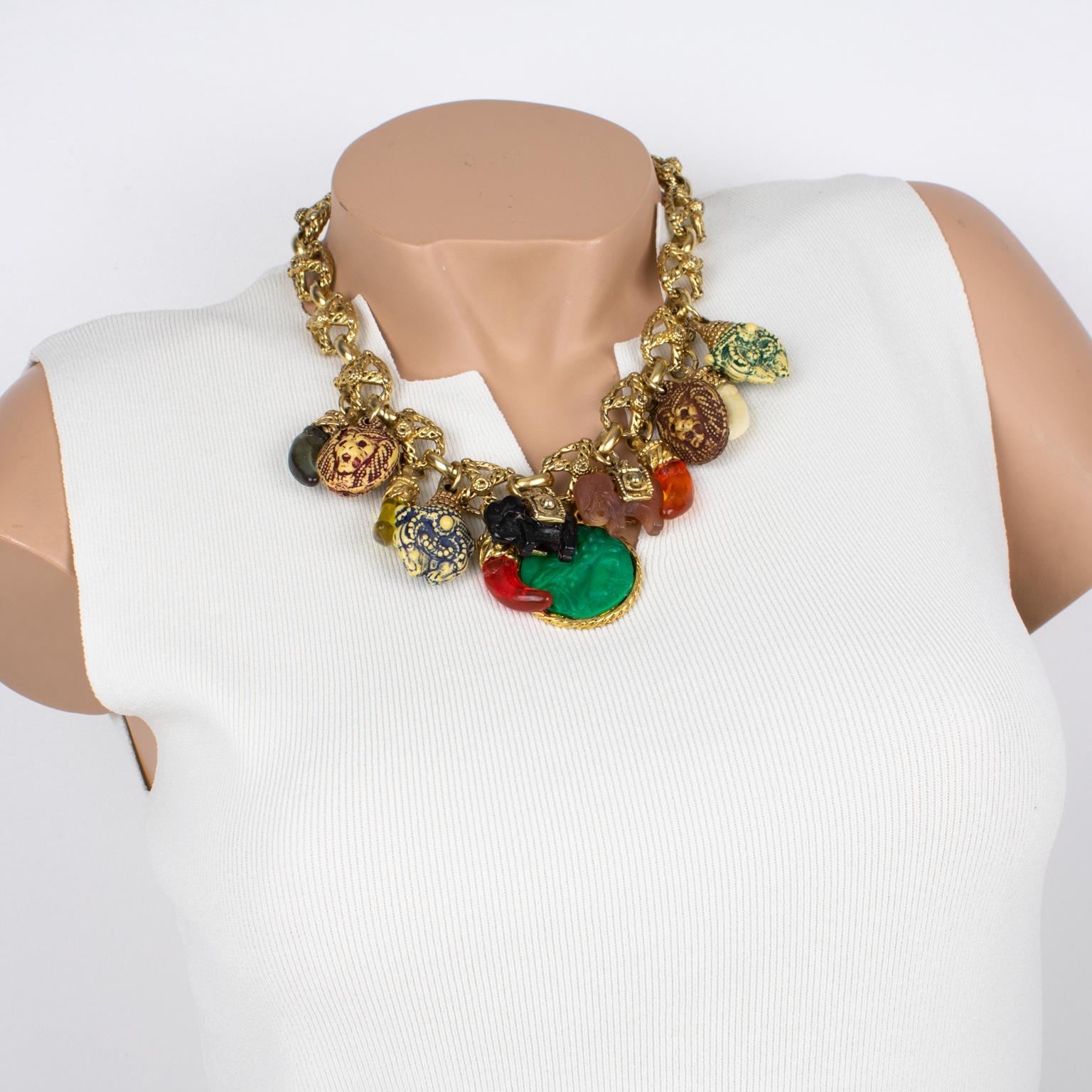 Diese ultra-schicke Halskette von Kalinger Paris besticht durch ihr typisches 1980er-Jahre-Design mit einer gearbeiteten, vergoldeten Metallkette, die mit mehrfarbigen Charms aus Harz verziert ist. Die baumelnden Charms mit Elefanten, Löwenköpfen,