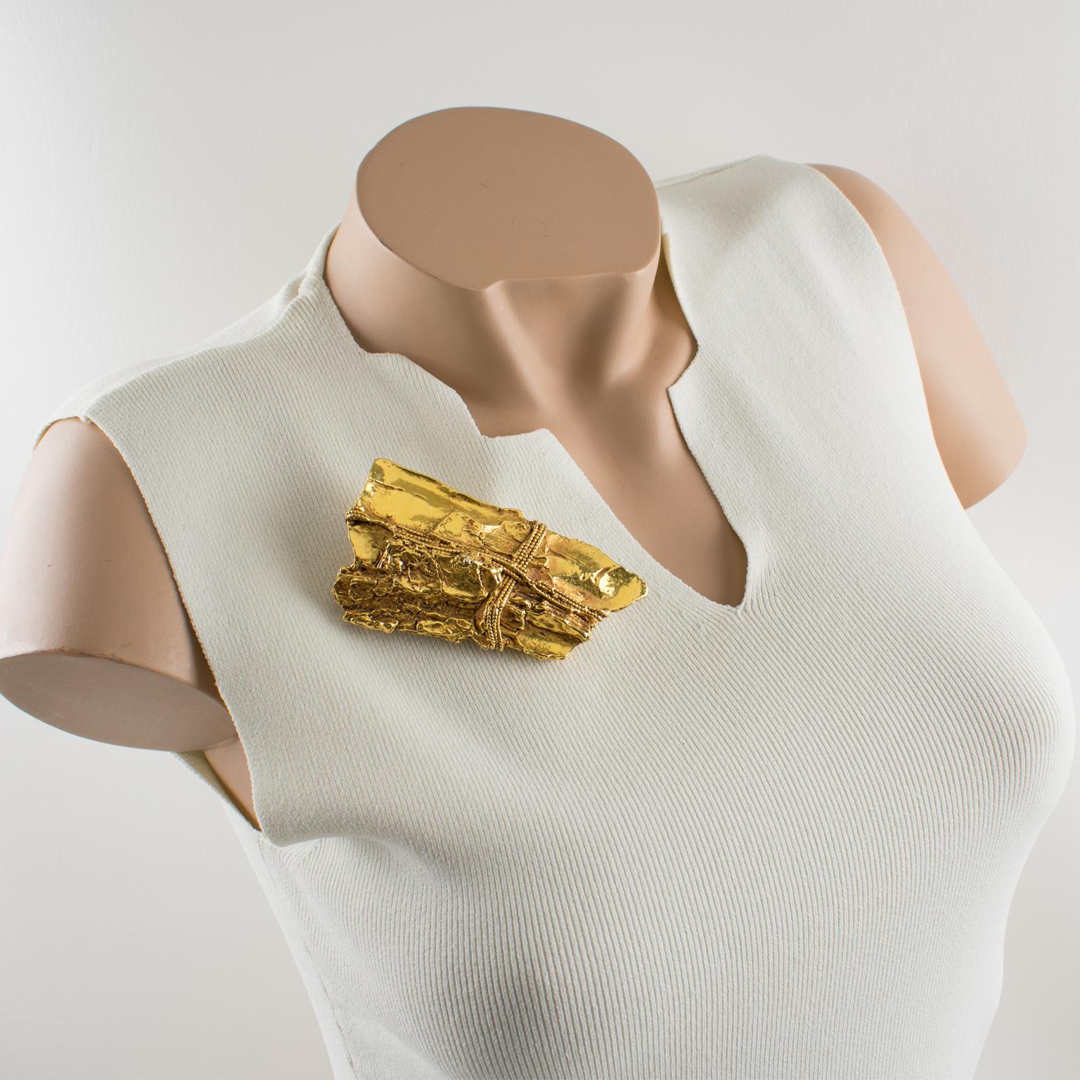 Este espectacular broche modernista de Kalinger Paris presenta un antiguo trozo de madera a la deriva dimensional envuelto con una cuerda de resina recubierta de metal dorado. Esta pieza es típica del estilo ochentero de este diseñador francés. El