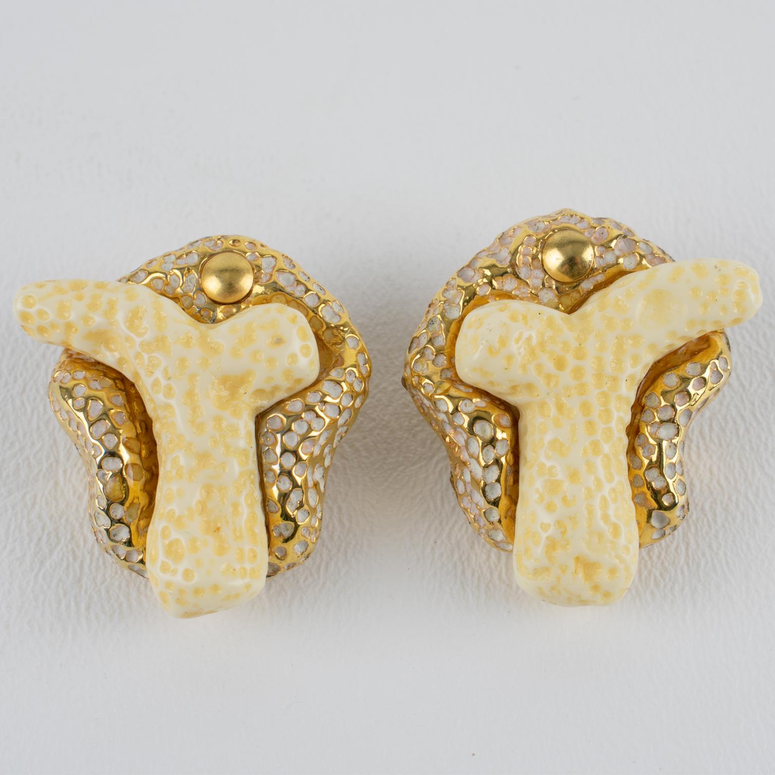 Estos preciosos pendientes de clip ornamentados de Kalinger Paris presentan una forma libre de resina recubierta de metal dorado con textura, rematada con una rama de resina de imitación coral. Esta pieza es típica del estilo ochentero de este
