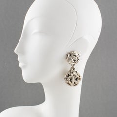 Boucles d'oreilles à clip signées Kalinger Paris avec boule en résine argentée en forme de boule et logo K