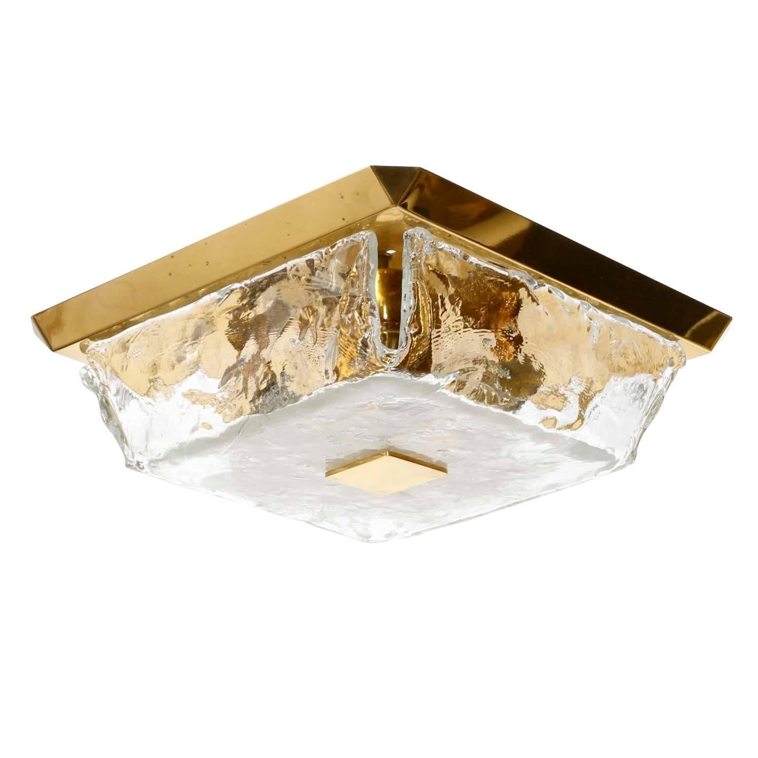 A square ceiling or wall lamp by J.T. Kalmar, Austria, manufactured in midcentury, circa 1970 (late 1960s or early 1970s).
It is made of a polished brass backplate which holds a Murano glass lampshade with a square brass bolt.
The light has two