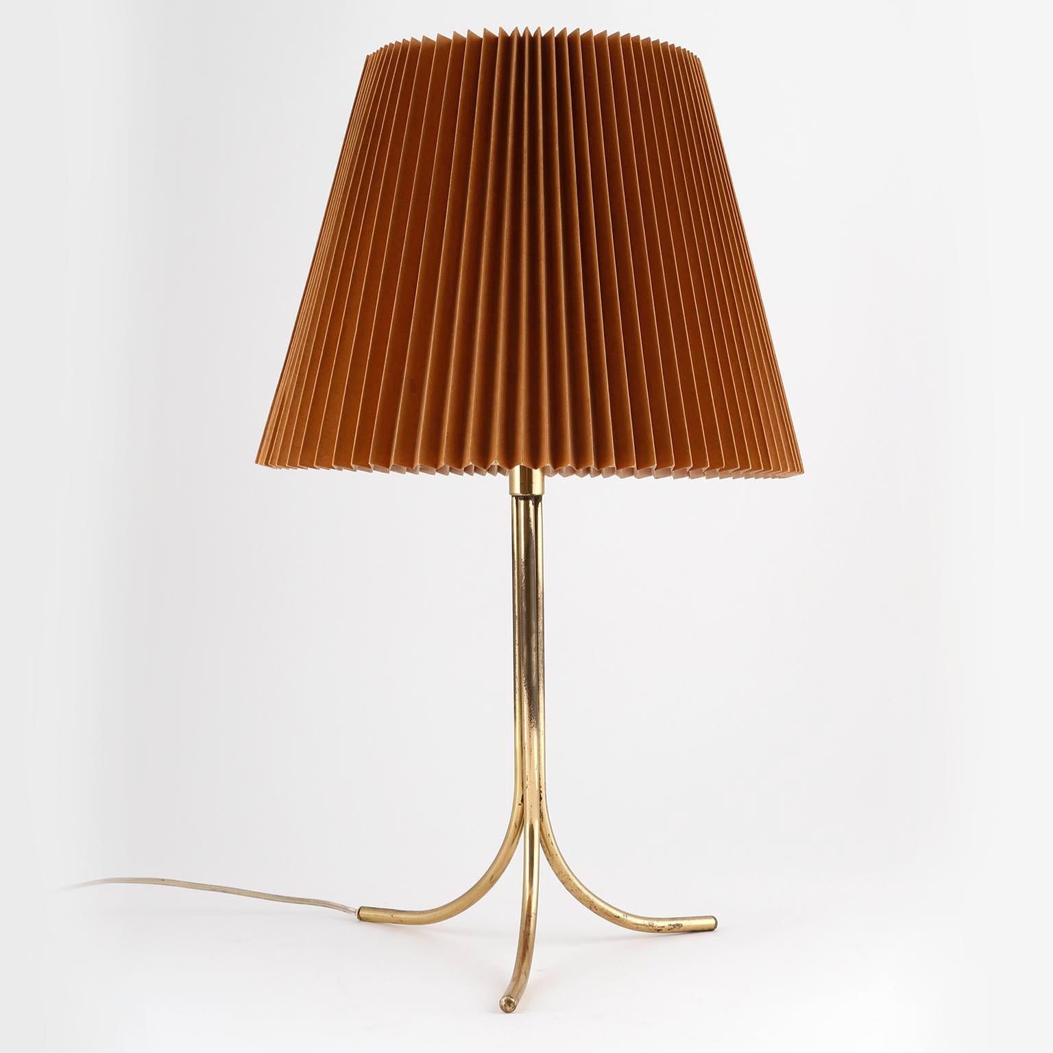 A rare table lamp model 'Dreibein' (engl. 'tripod') no. 1093 by J.T. Kalmar, Vienna, manufactured in midcentury, circa 1960 (late 1950s or 1960s).
The light is documented in the Kalmar catalogue from 1960.
It is made of a solid brass stand and a