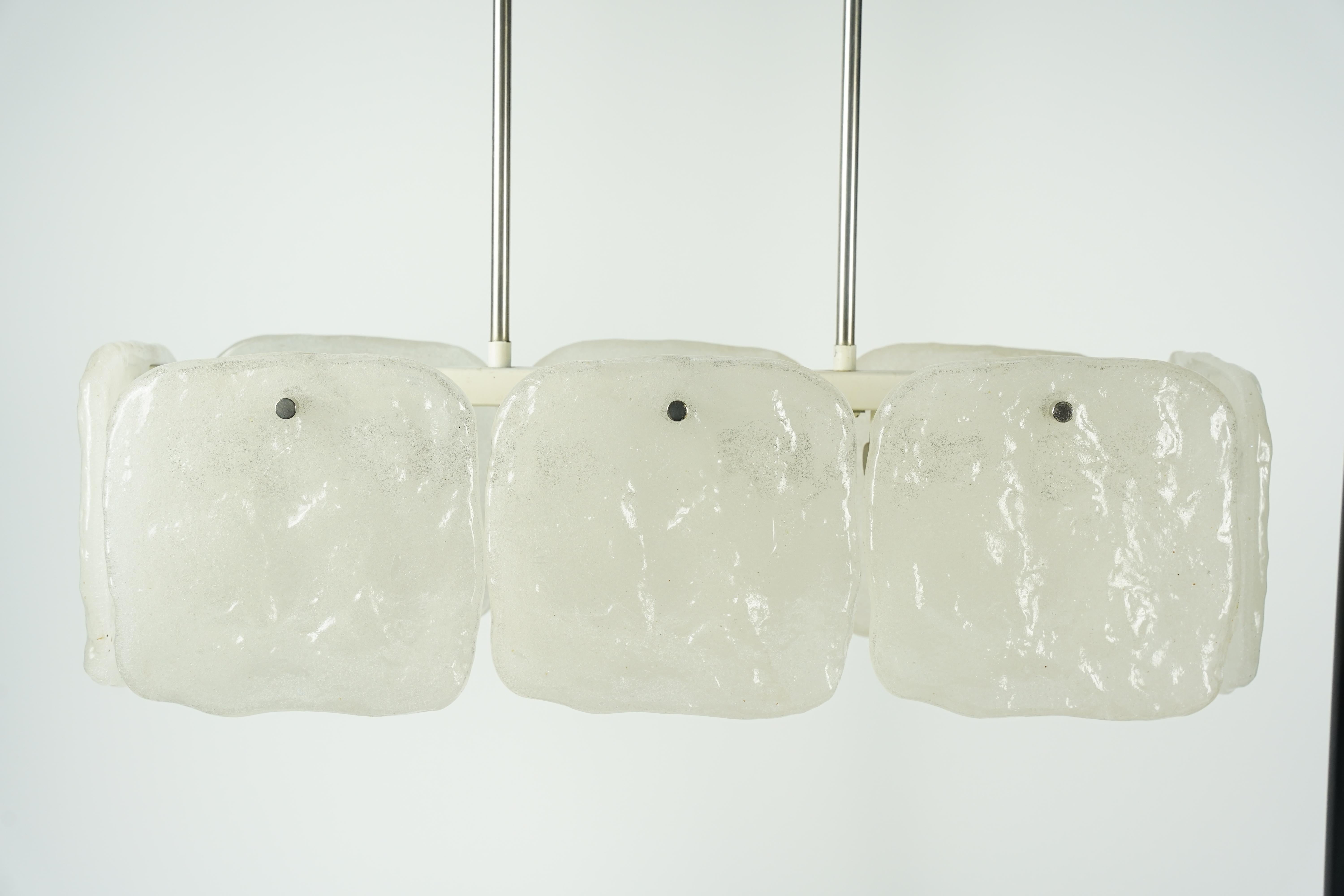 Lámpara de techo Kalmar Austria 1970, marco blanco sostenido por dos vástagos cromados  5 casquillos de luz cubiertos por 8 piezas cuadradas individuales y planas de cristal saturado de numerosas burbujas de aire diminutas que hacen que el cristal