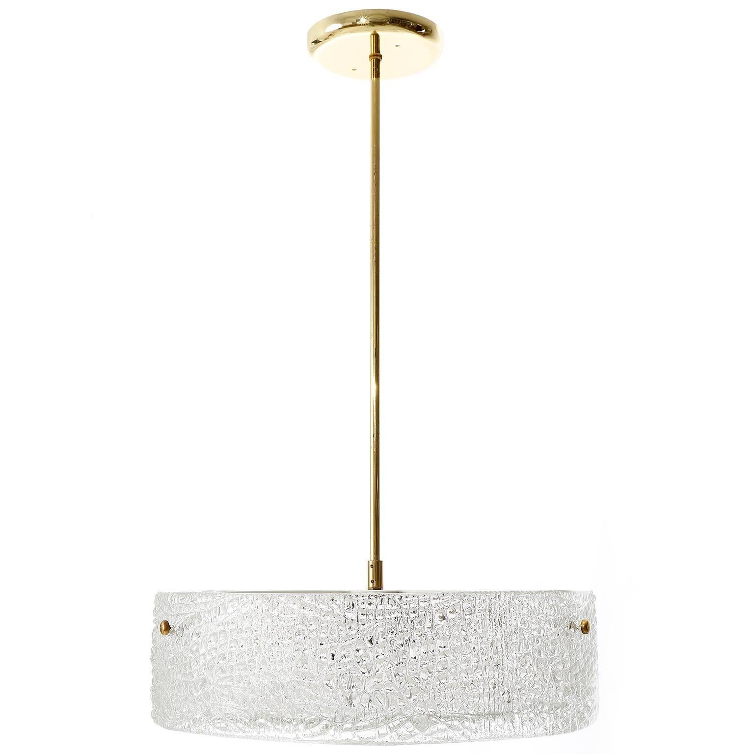 A beautiful textured glass and brass light fixture by J.T. Kalmar, Vienna, manufactured in midcentury, circa 1960 (late 1950s or early 1960s).
A round glass ring is mounted with three brass bolts on a white enameled metal frame. A textured glass