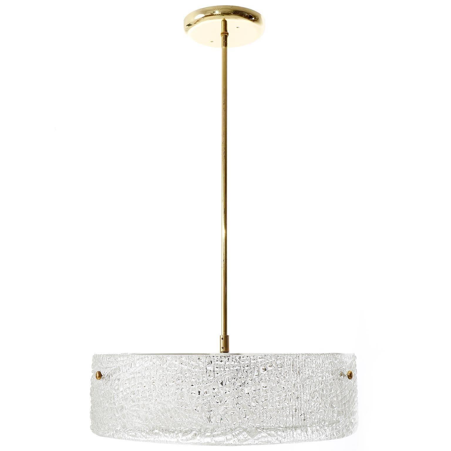 A beautiful textured glass and brass light fixture by J.T. Kalmar, Vienna, manufactured in midcentury, circa 1960 (late 1950s or early 1960s).
A round glass ring is mounted with three brass bolts on a white painted metal frame. A textured glass disc