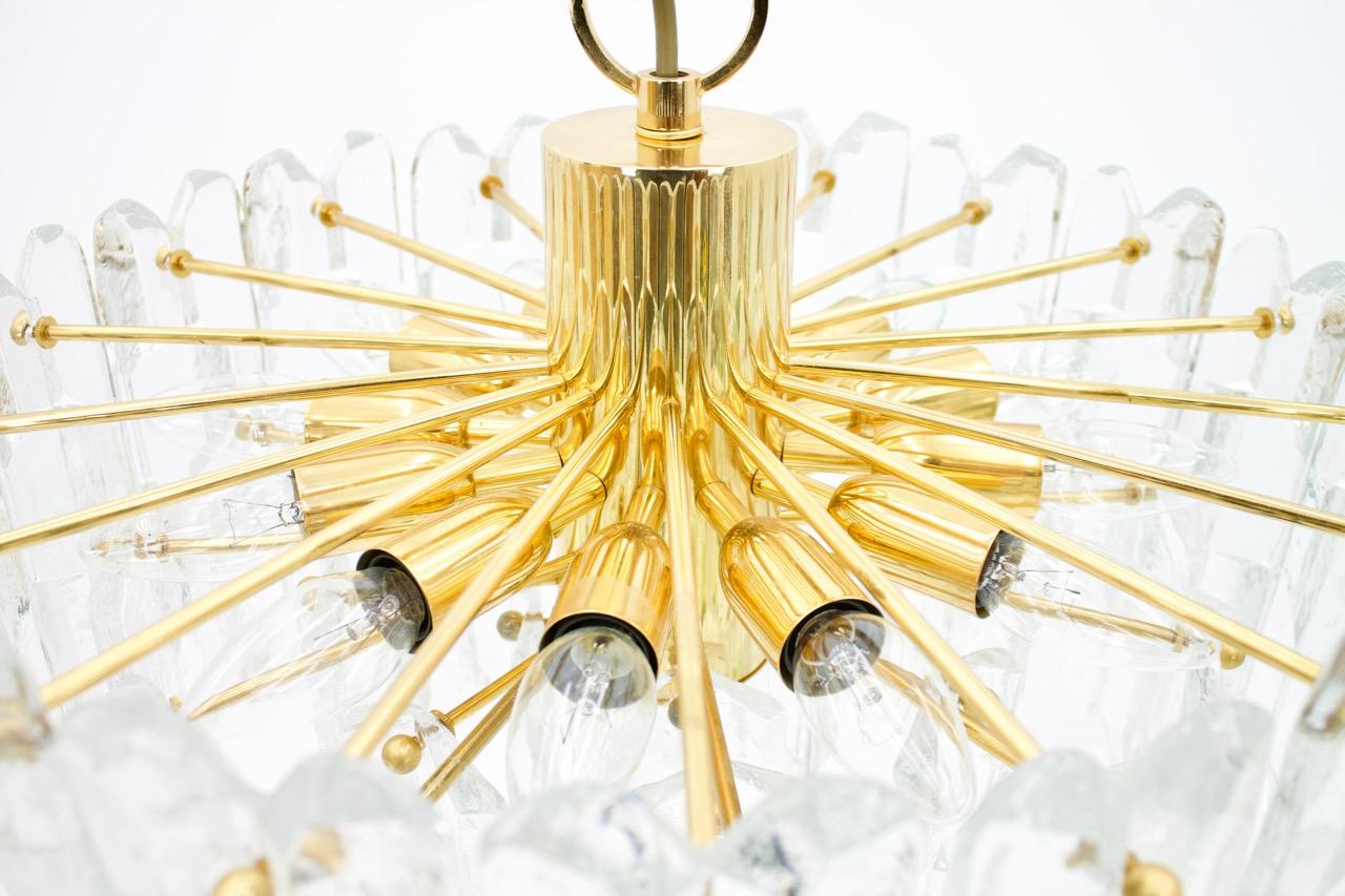 'Palazzo' 24 carat plated brass and clear glass chandelier by Kalmar Austria. The chandelier is marked with the Kalmar label. 
The chandelier has 12 socked for small bulbs (E14) with max. 40 Watts per bulb and one socket for a large bulb (E27). The