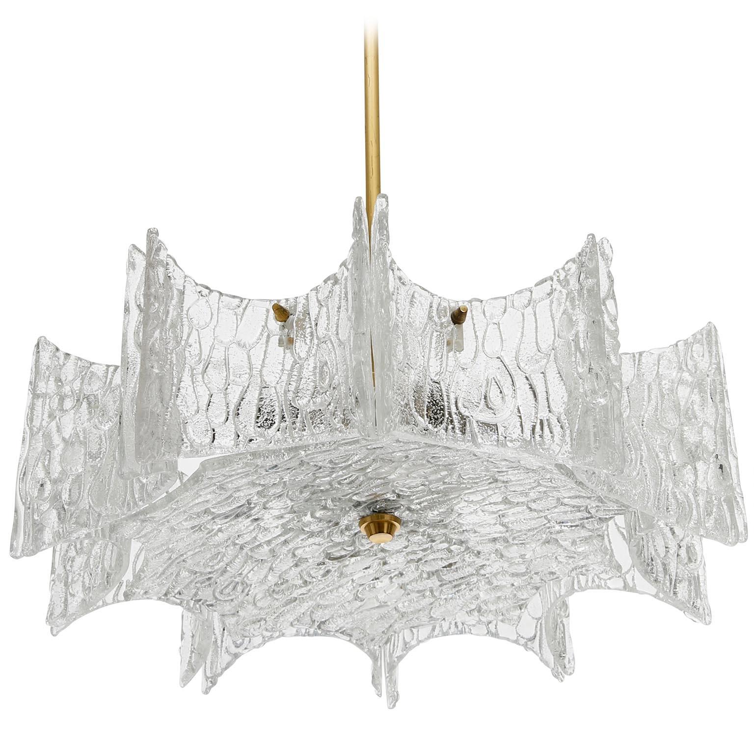 A star-shaped ceiling light by Kalmar manufactured in Austria in midcentury, circa 1970 (late 1960s or early 1970s).
The lamp is made of frosted ice glass pieces mounted on a white lacquered frame and a brass stem and canopy.
The light has been