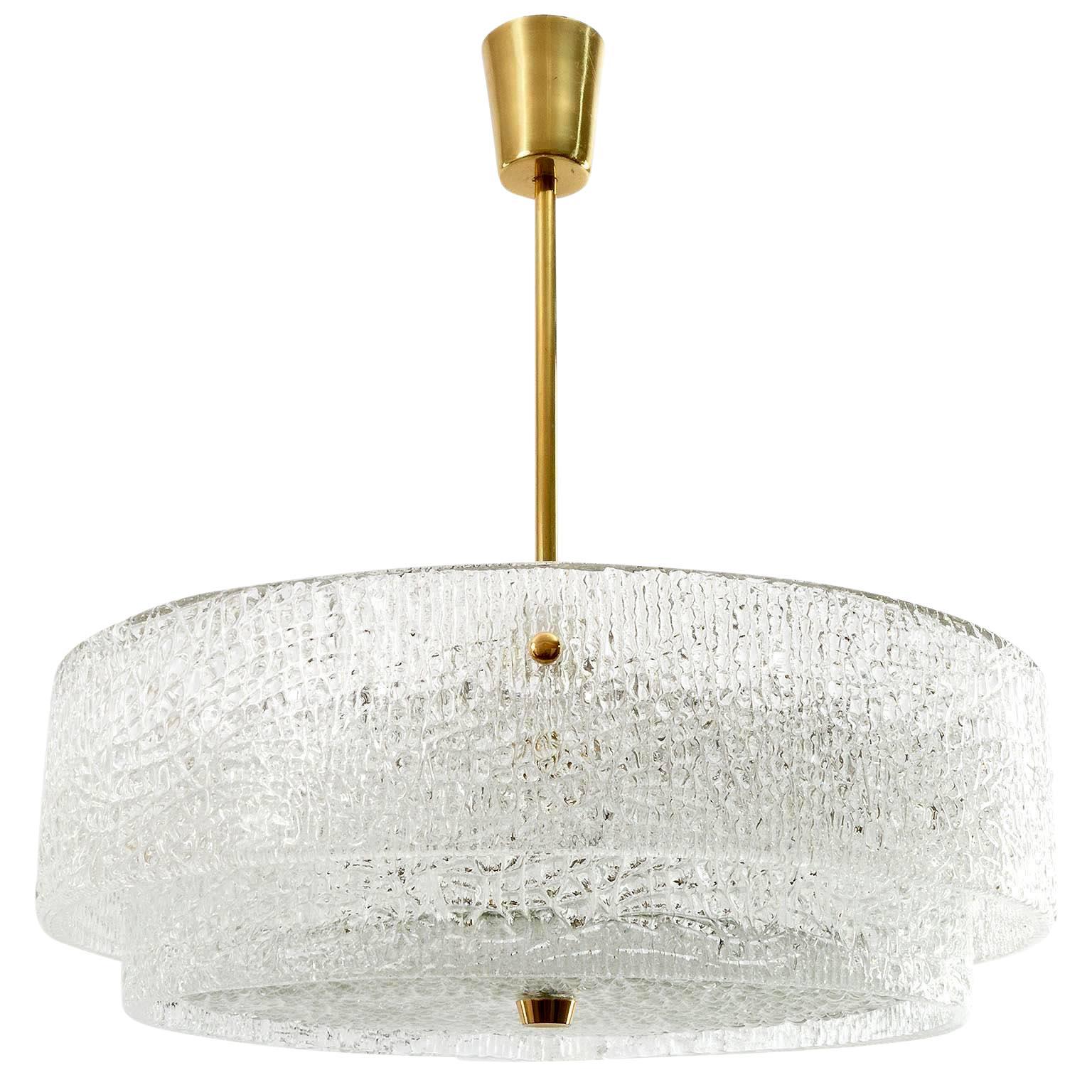 A beautiful textured glass and brass light fixture by J.T. Kalmar, Vienna Austria, manufactured in midcentury, circa 1960 (late 1950s or early 1960s).
Two round glass belts are mounted on a white enameled metal frame. A round glass disk is fixed