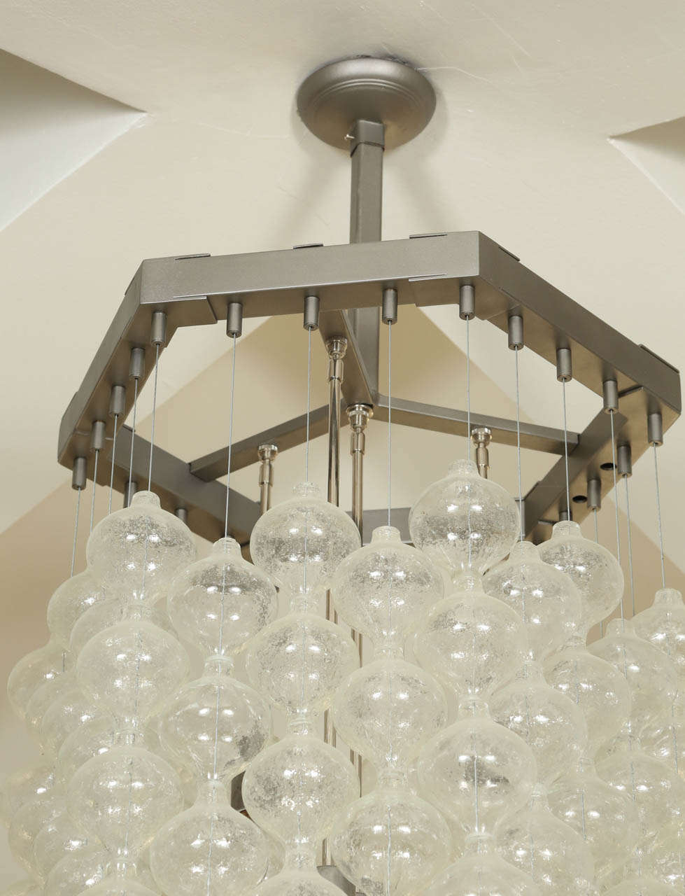 Kalmar chandelier with tulipan nestling glass elements.
The hexagonal frame is Industrial steel and there are four light sources.