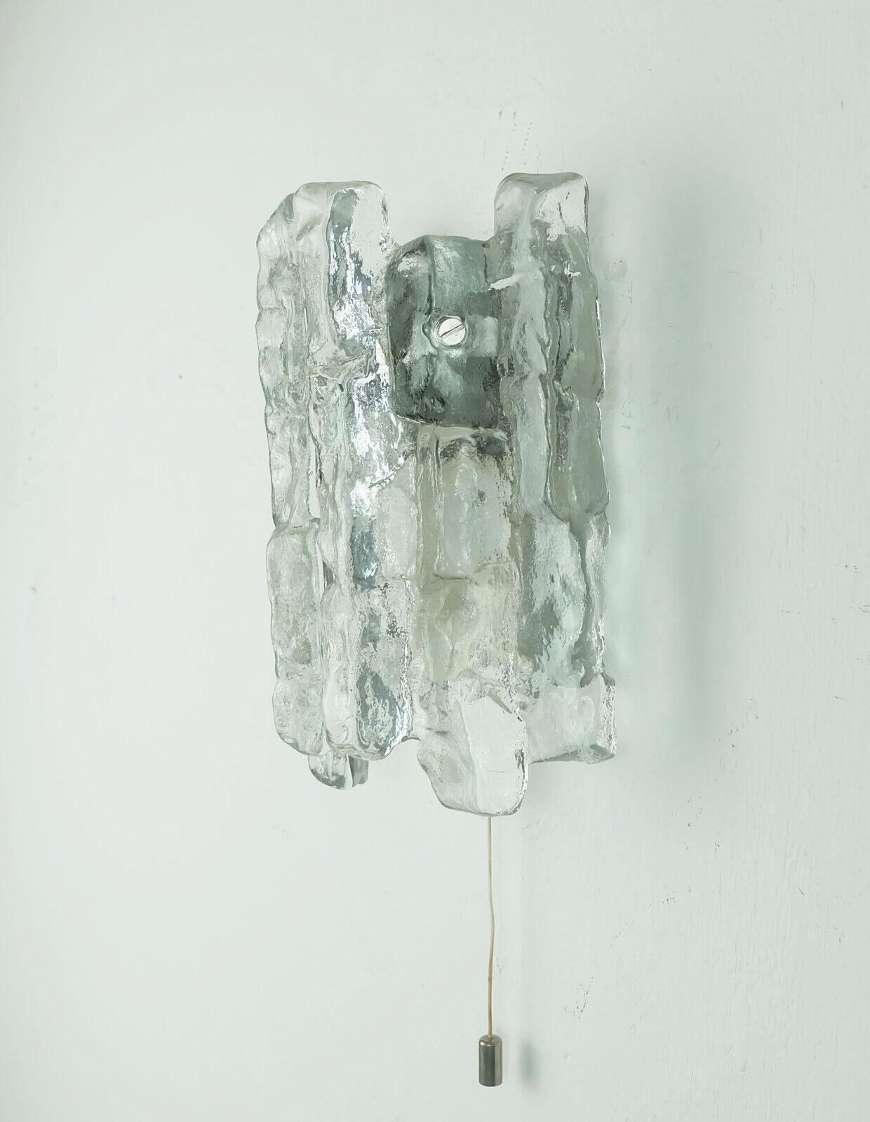 Mid century wall lamp manufactured in the 1960s / 70s by Kalmar Franken (model 4541/1, series 106/6/8). Thick structured glass in ice look, silver-colored metal wall mount. Holds one E14 light bulb.

Dimensions in cm:
Height 19 cm, width 13 cm,