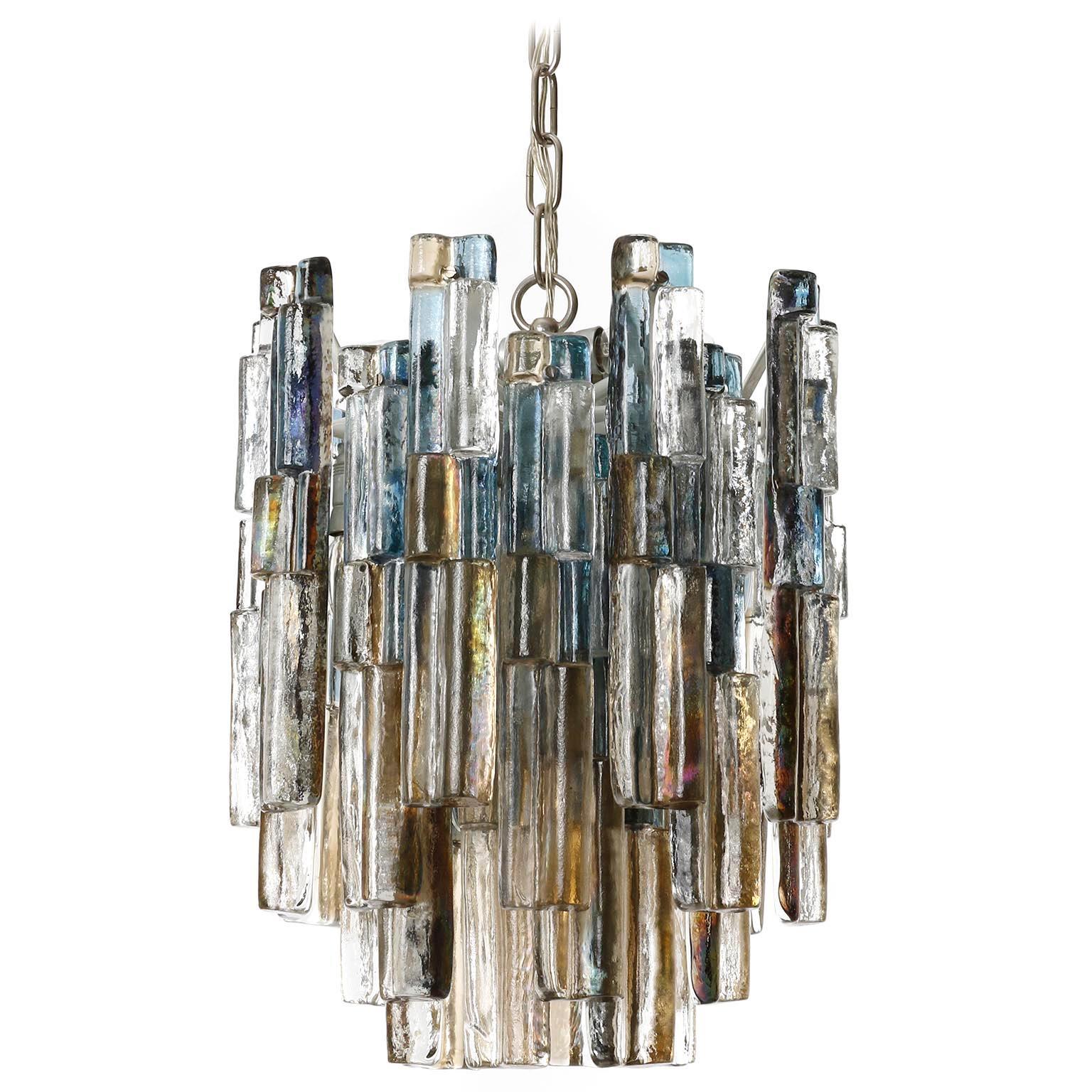 A gorgeous pendant light fixture by Kalmar, Austria, manufactured in midcentury, circa 1970 (late 1960s or early 1970s). 
Two lights are available. The price is per light.
Each lamp is made of clear, blue and amber toned cast ice glass blocks which