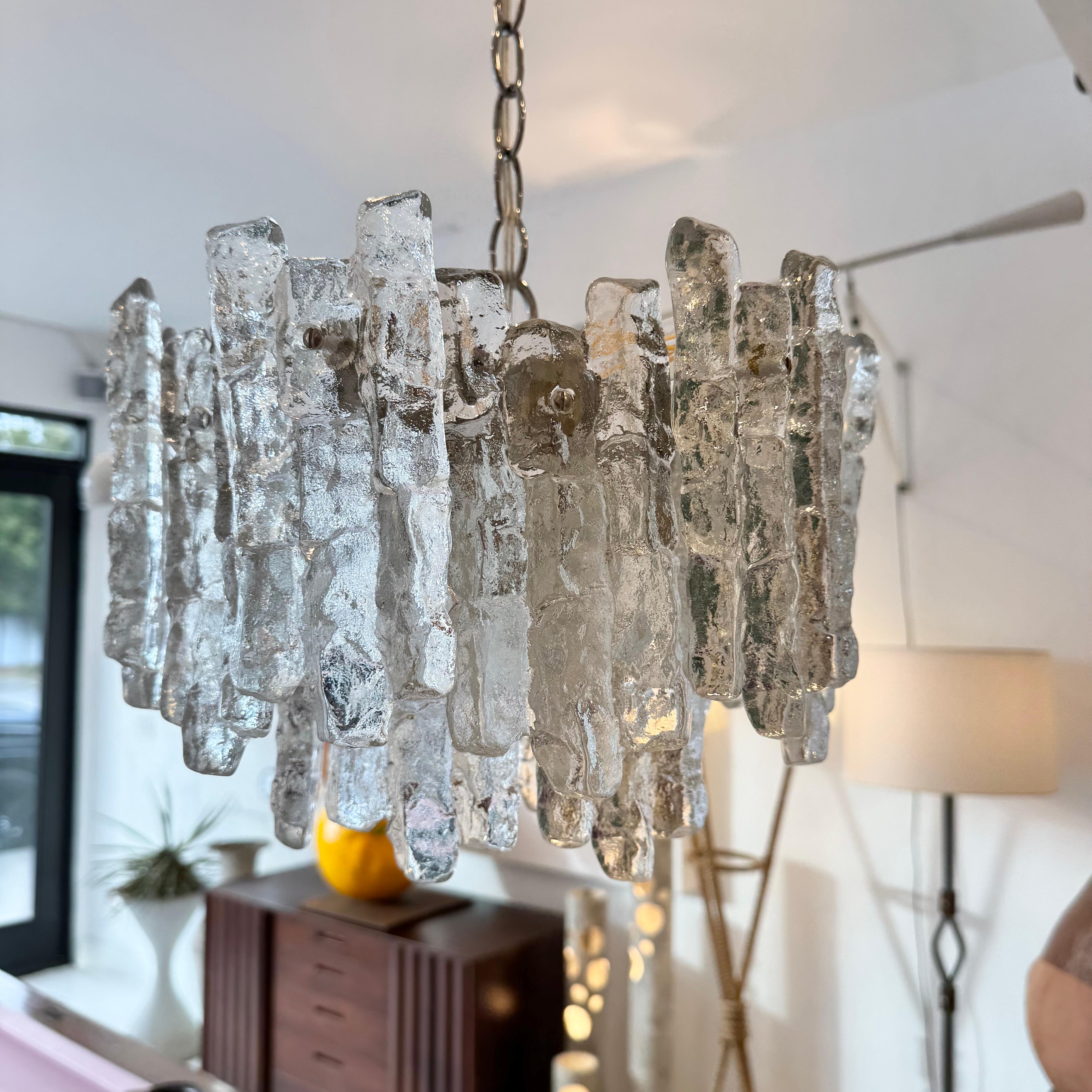 Elegante lampadario di Kalmar. Prodotto in Austria, negli anni '60. Catena e tettuccio cromati. Prese originali europee con nuovo cablaggio statunitense con sette prese a candelabro. I vetri appesi ricordano i ghiaccioli. Il lampadario si illumina